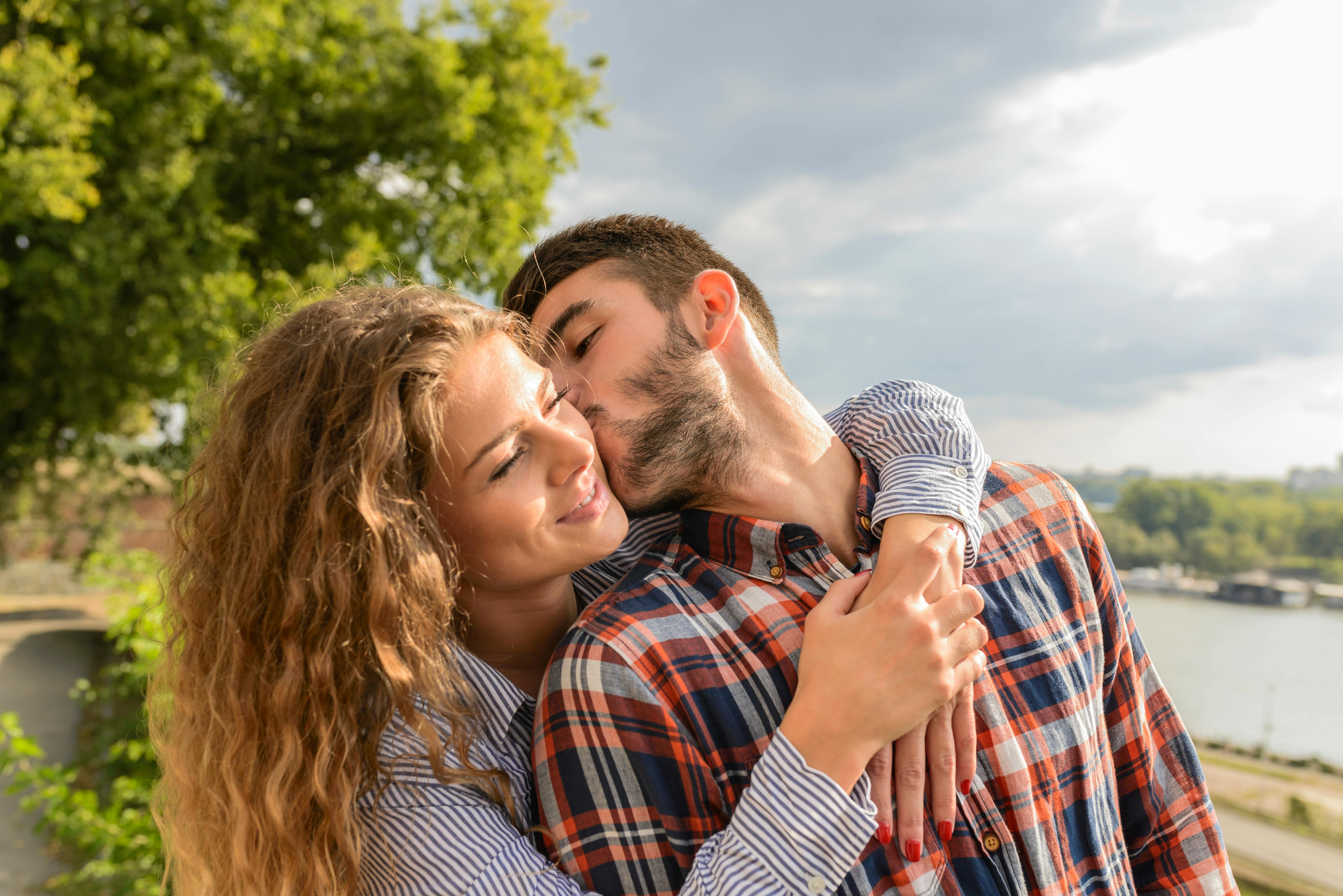 A man kissing a woman on the cheek | Source: Pexels