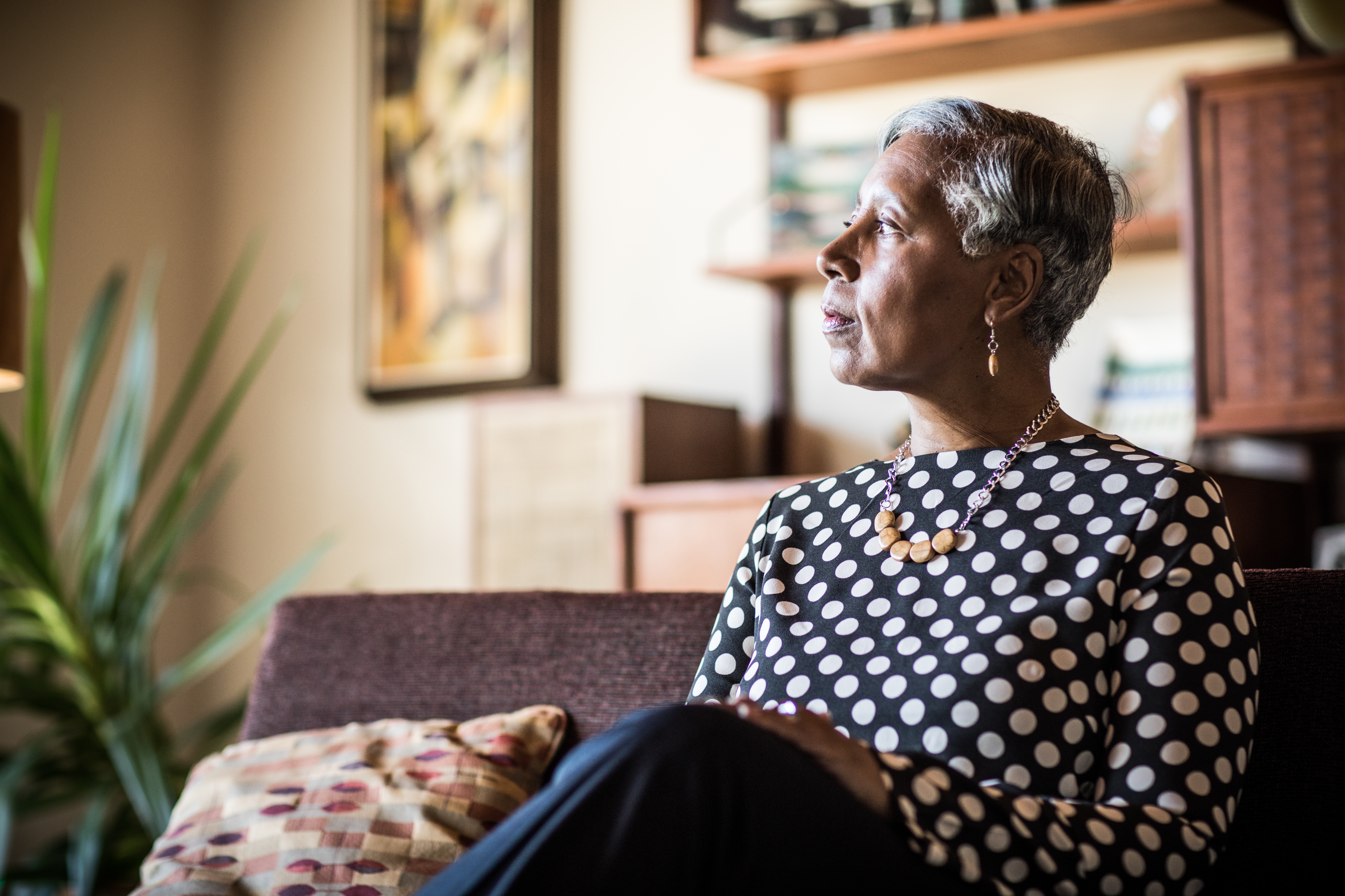 Portrait of woman (60yrs) sitting on couch at home | Source: Getty Images