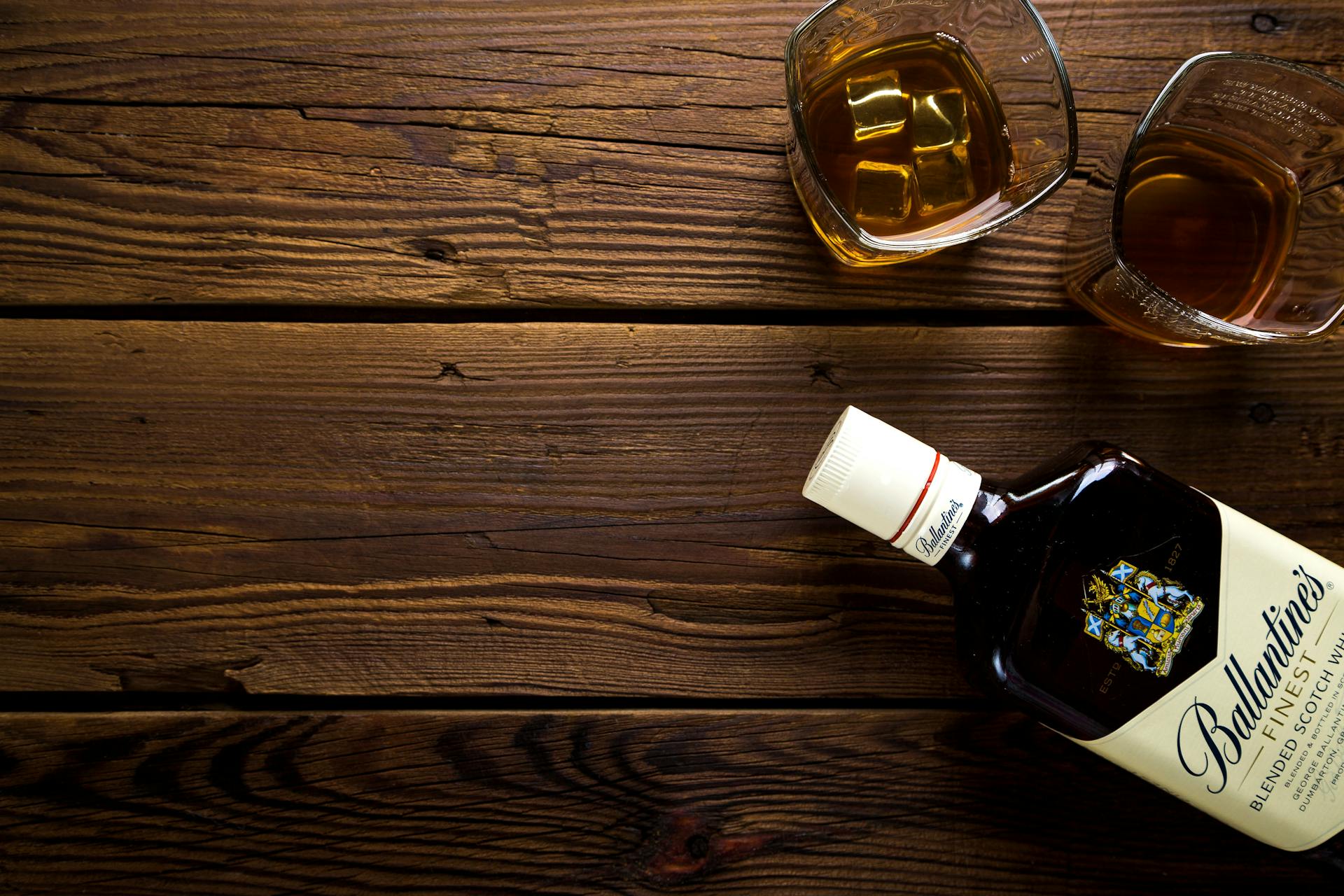 Two glasses and a bottle of alcohol on a table | Source: Pexels