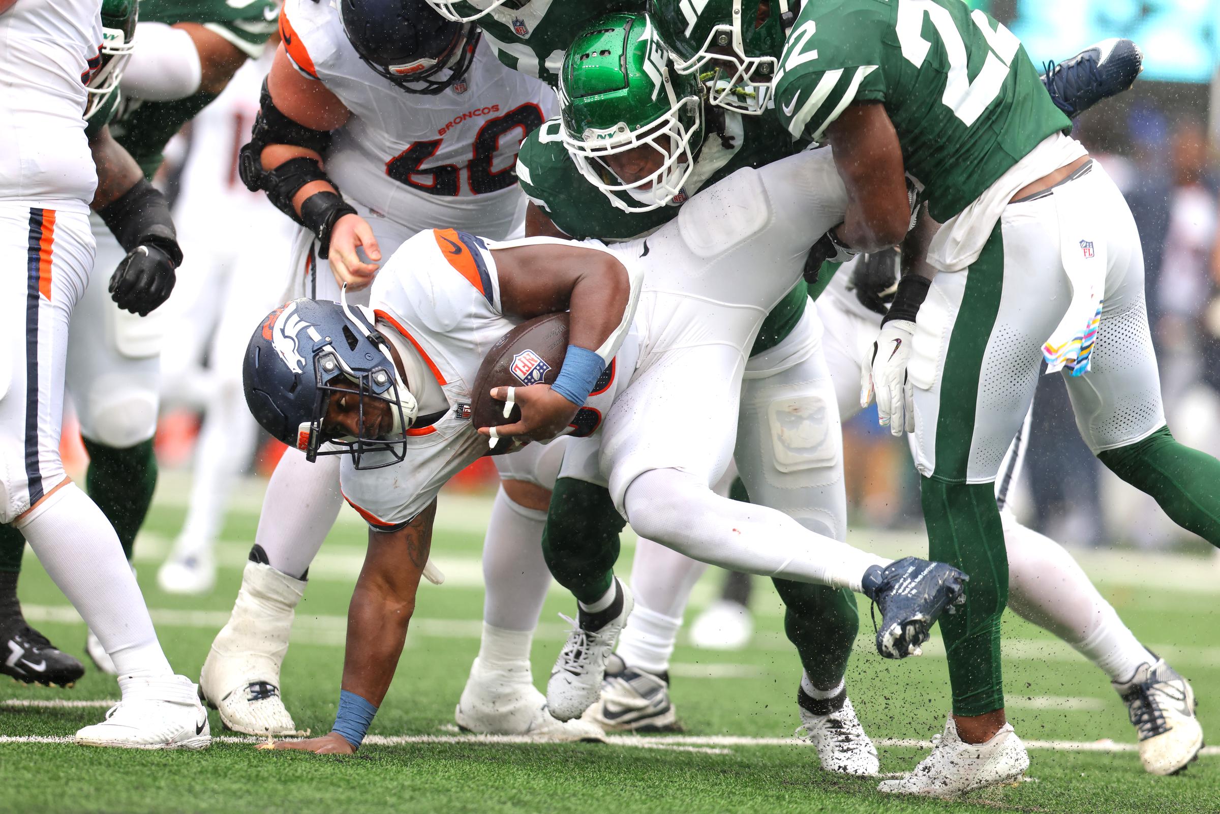 Tyler Badie being tackled to the ground by New York Jets players during the second quarter of their game in East Rutherford, New Jersey on September 29, 2024 | Source: Getty Images