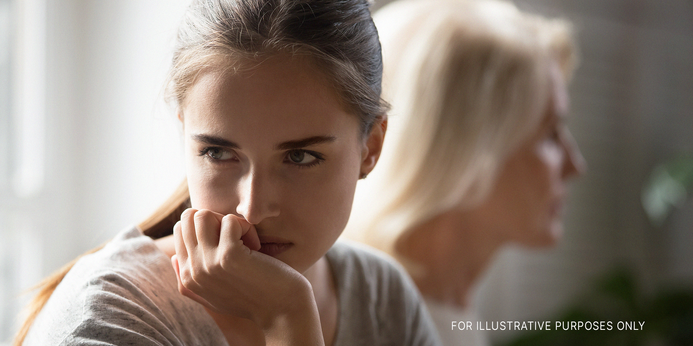 An upset young woman looking way from an older one in the background | Source: Shutterstock