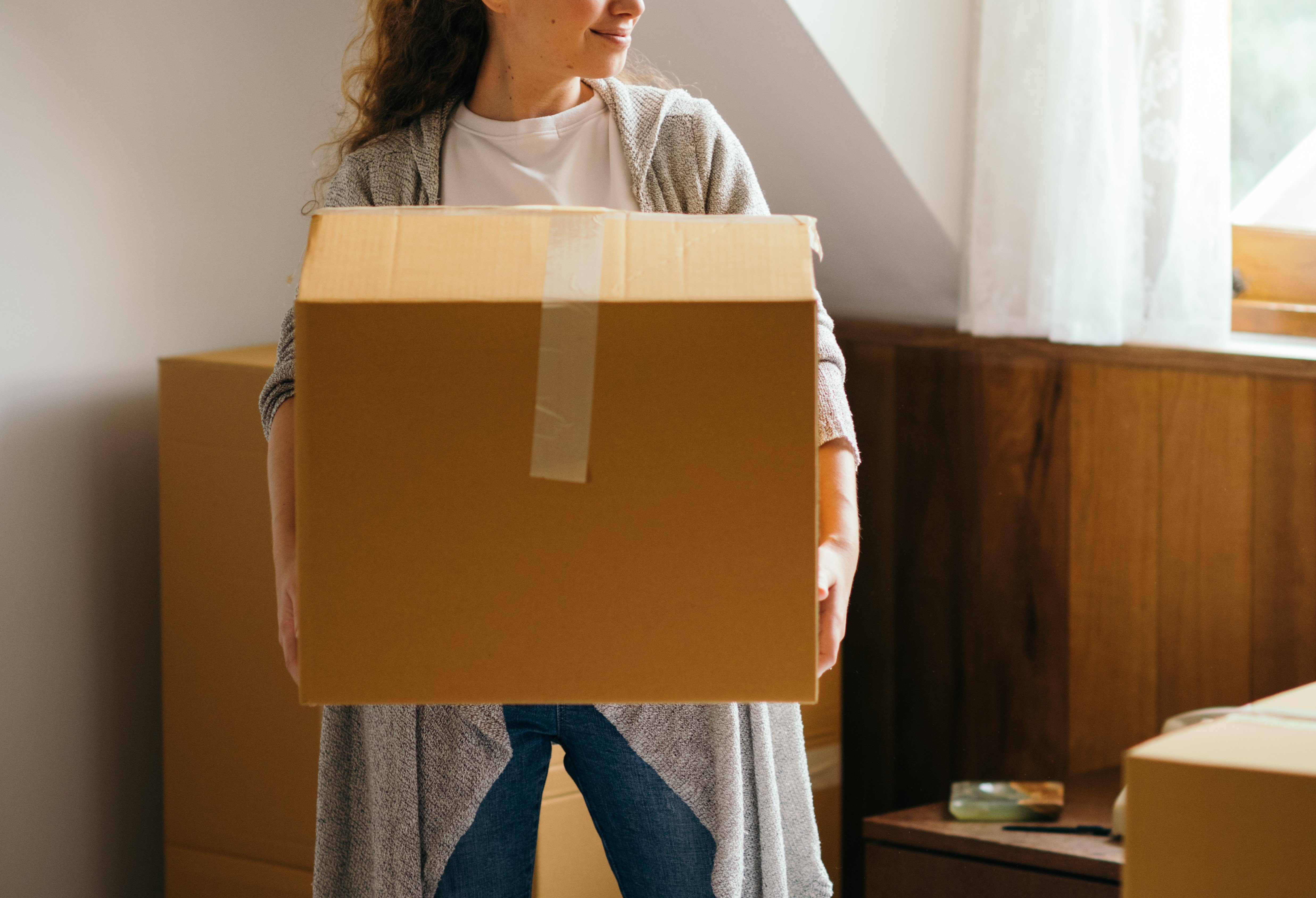 Mujer cargando una caja. | Foto: Pexels