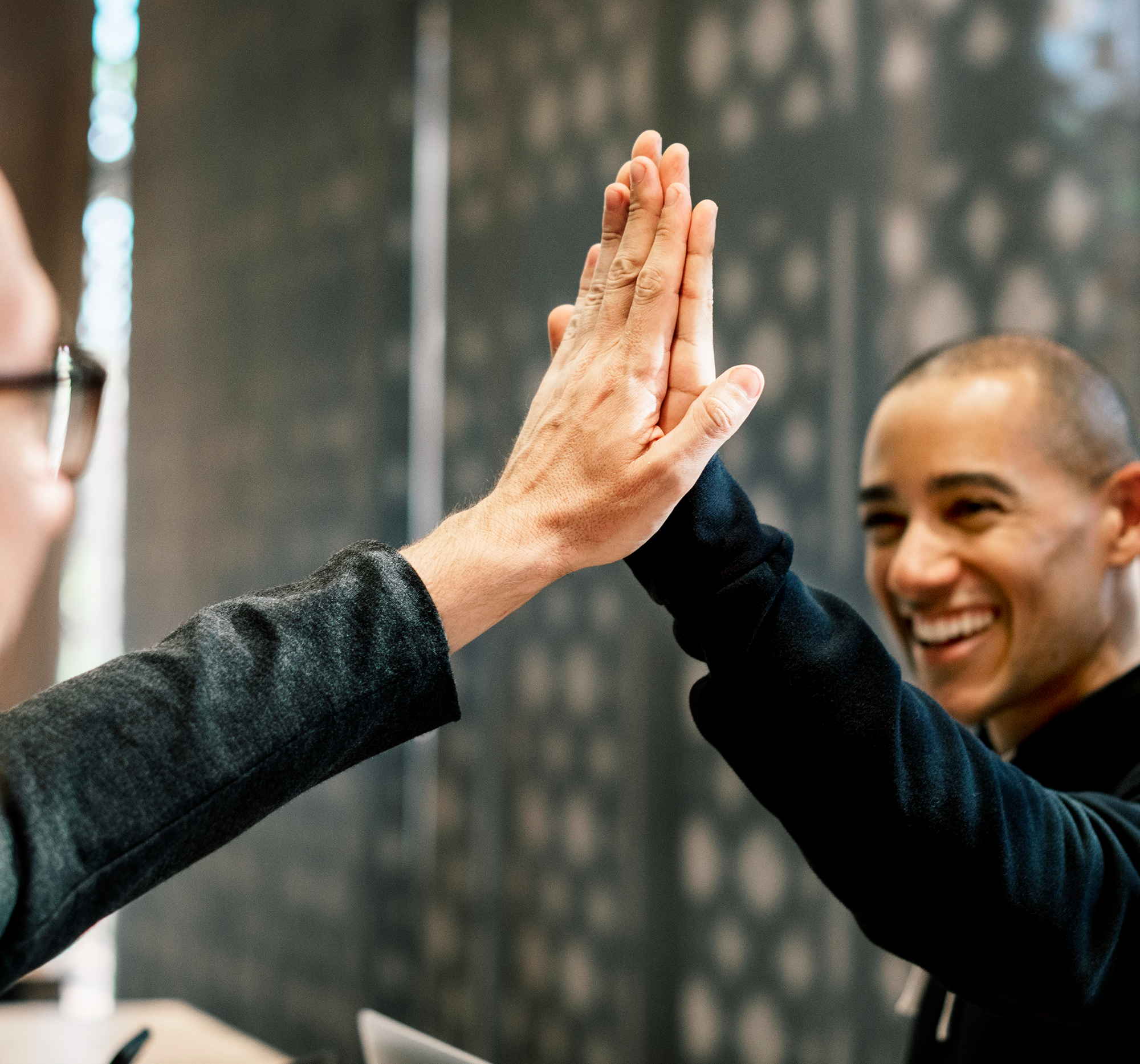 Colleagues giving each other a high five | Source: Freepik