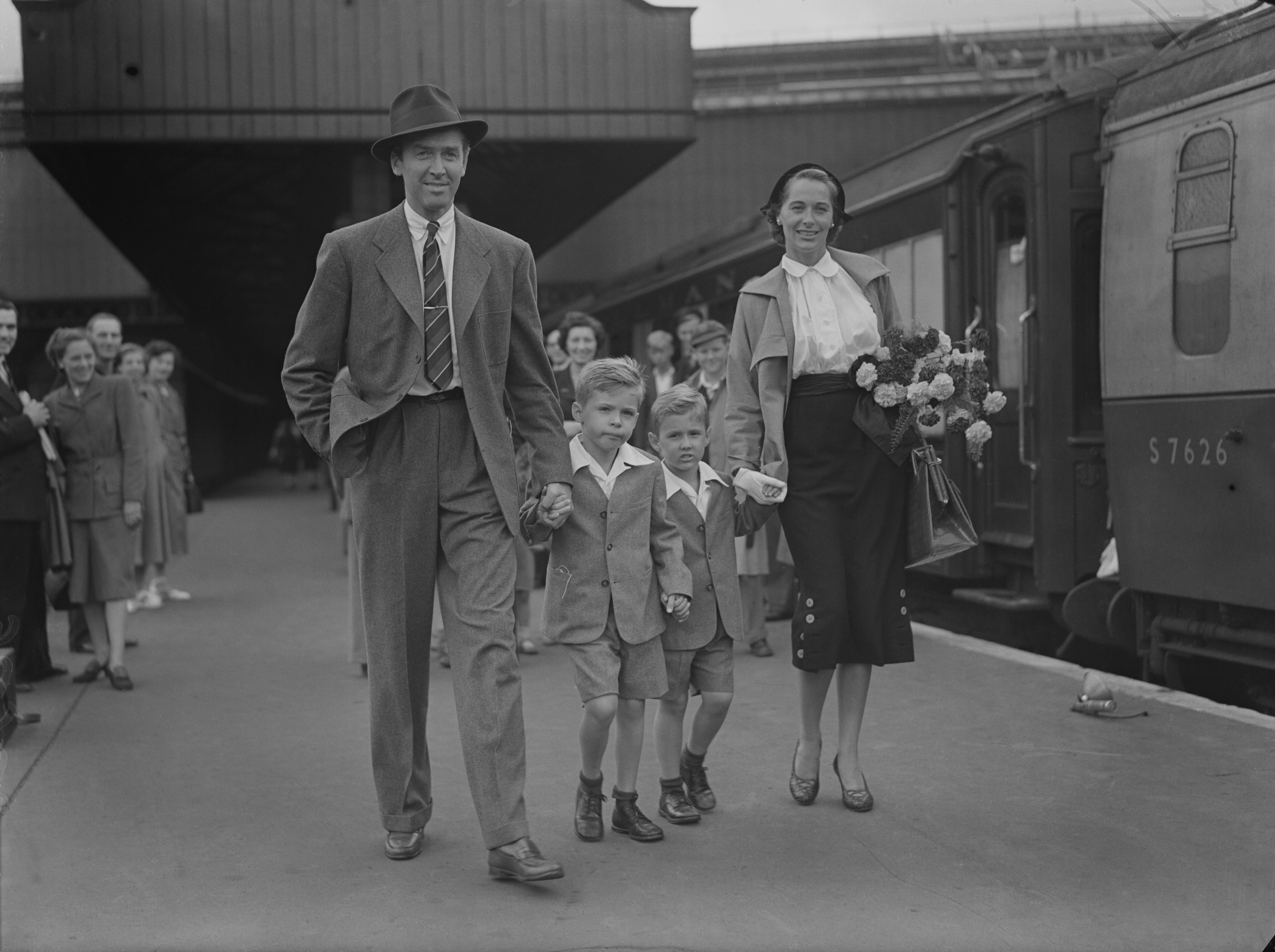 James Stewart and Gloria Hatrick McLean and her sons Ronald (left) and Michael at Waterloo Station in London on August 28, 1950 | Source: Getty Images