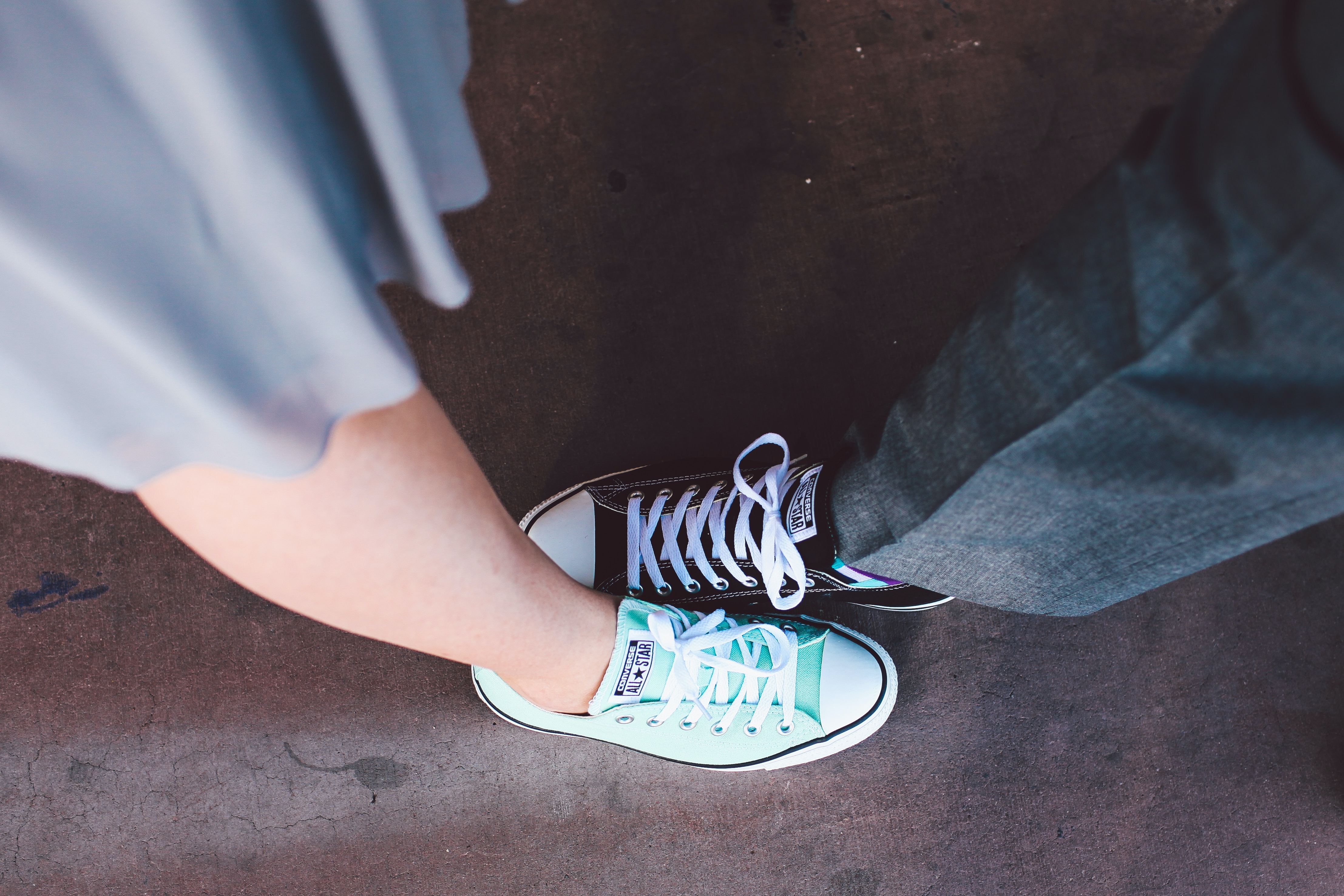 Two individuals wearing All Star converse shoes. | Source: Unsplash