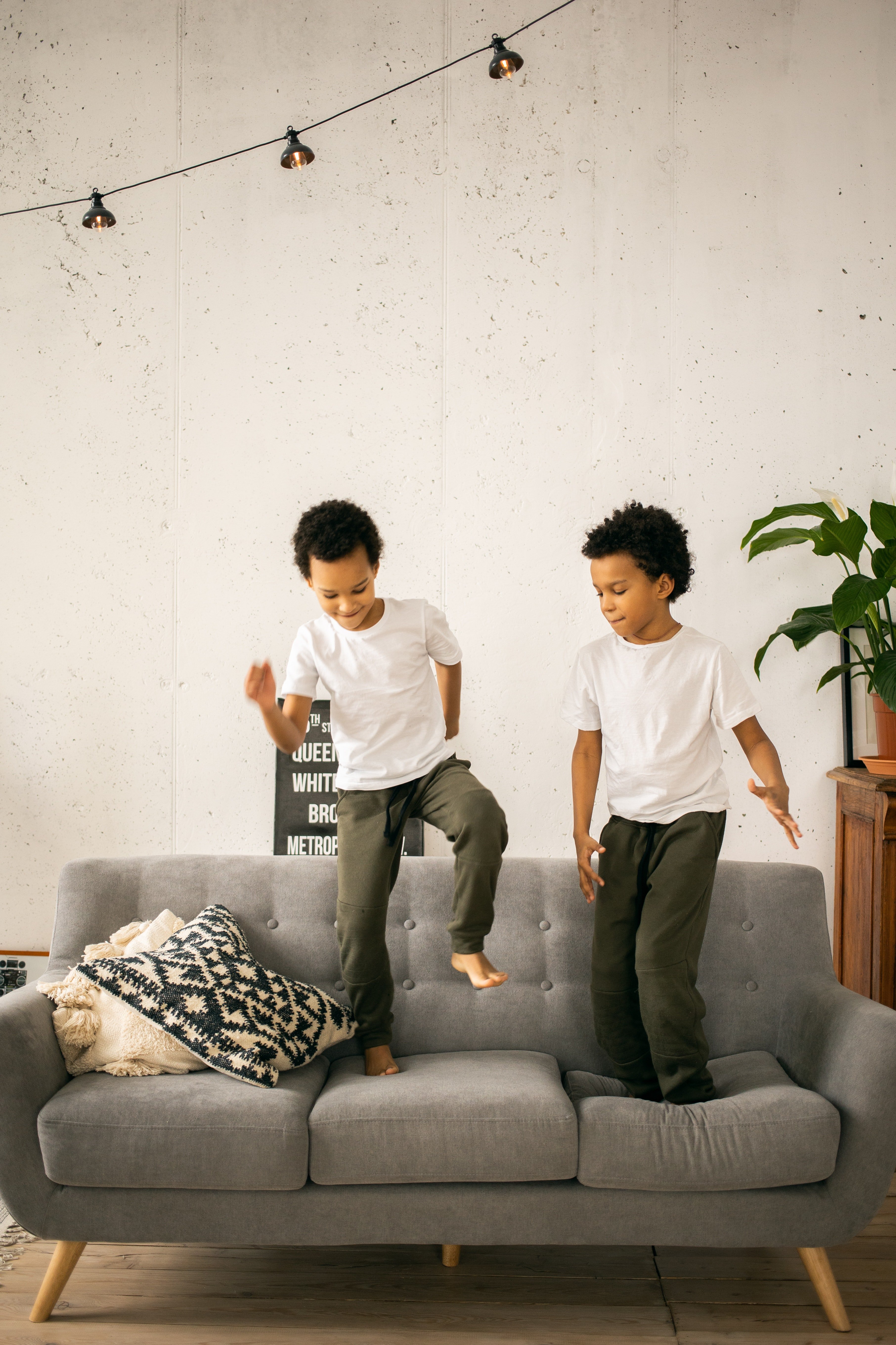 Identical twins jumping on the sofa | Photo: Pexels