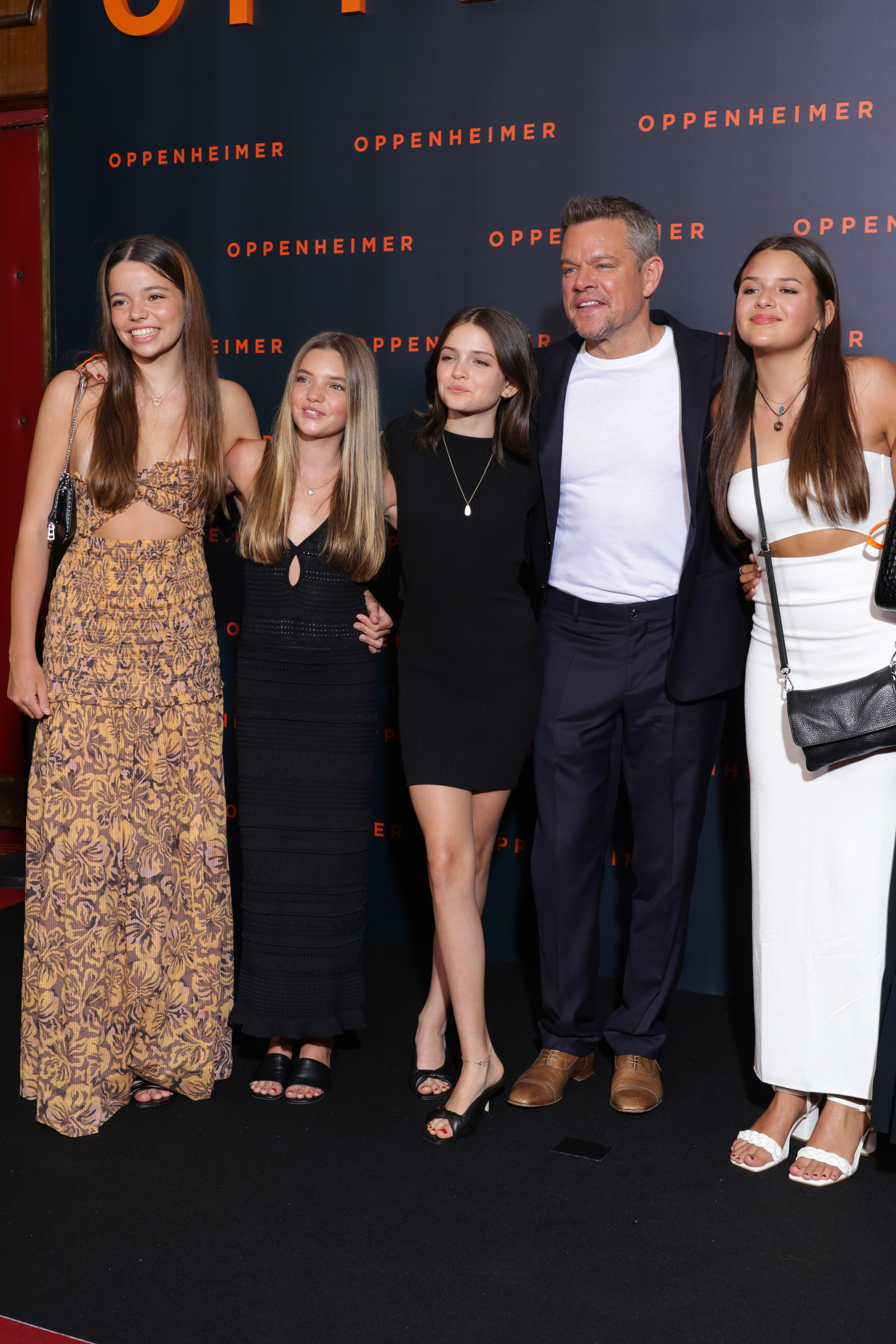 Matt Damon poses with daughters Alexia Barroso, Isabella Damon, Gia Damon, and Stella Damon at the Paris premiere of "Oppenheimer," showcasing one of the family's rare public appearances together. | Source: Getty Images