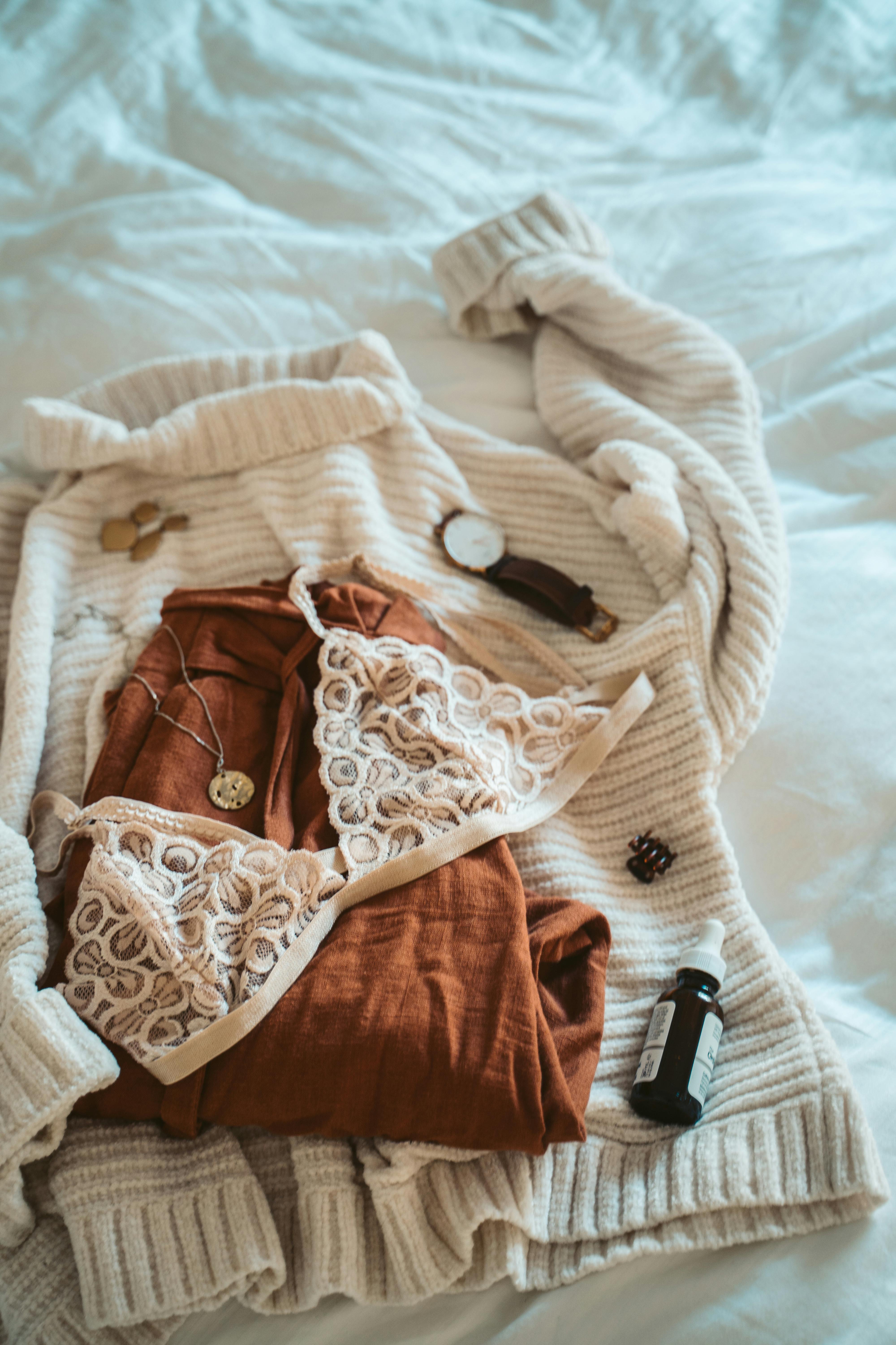 A bra, top, pants, and accessories laid out on a surface | Source: Pexels
