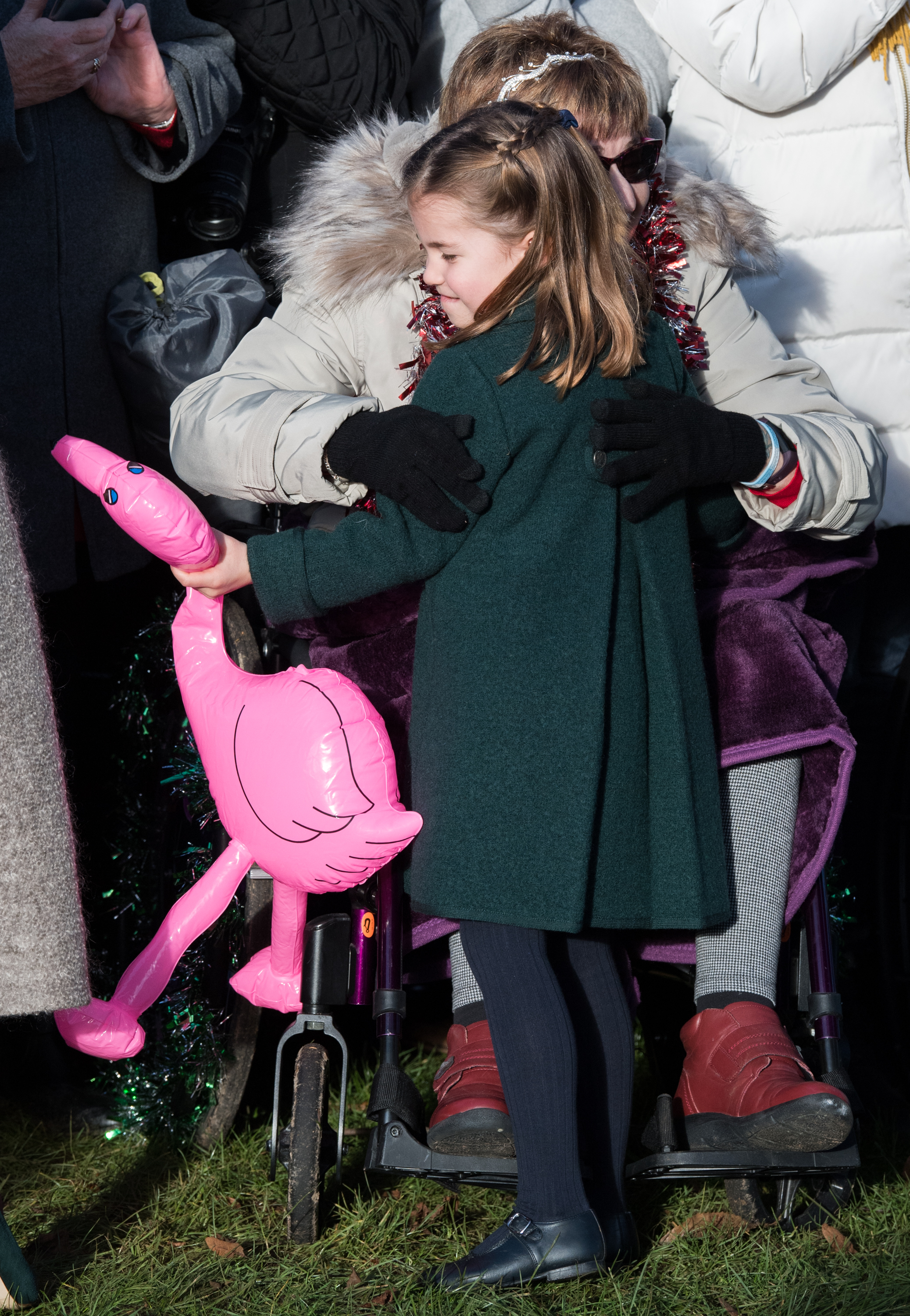 A beaming four-year-old Charlotte, clutching a bright pink inflatable flamingo gifted by a wellwisher, throws her arms around the same admirer during the Christmas Day service at Sandringham in 2019.
