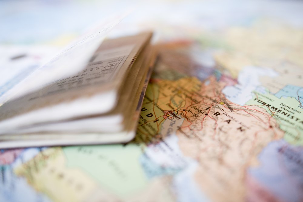Un pasaporte con sellos de entrada sobre un mapa geográfico del mundo. | Foto: Shutterstock