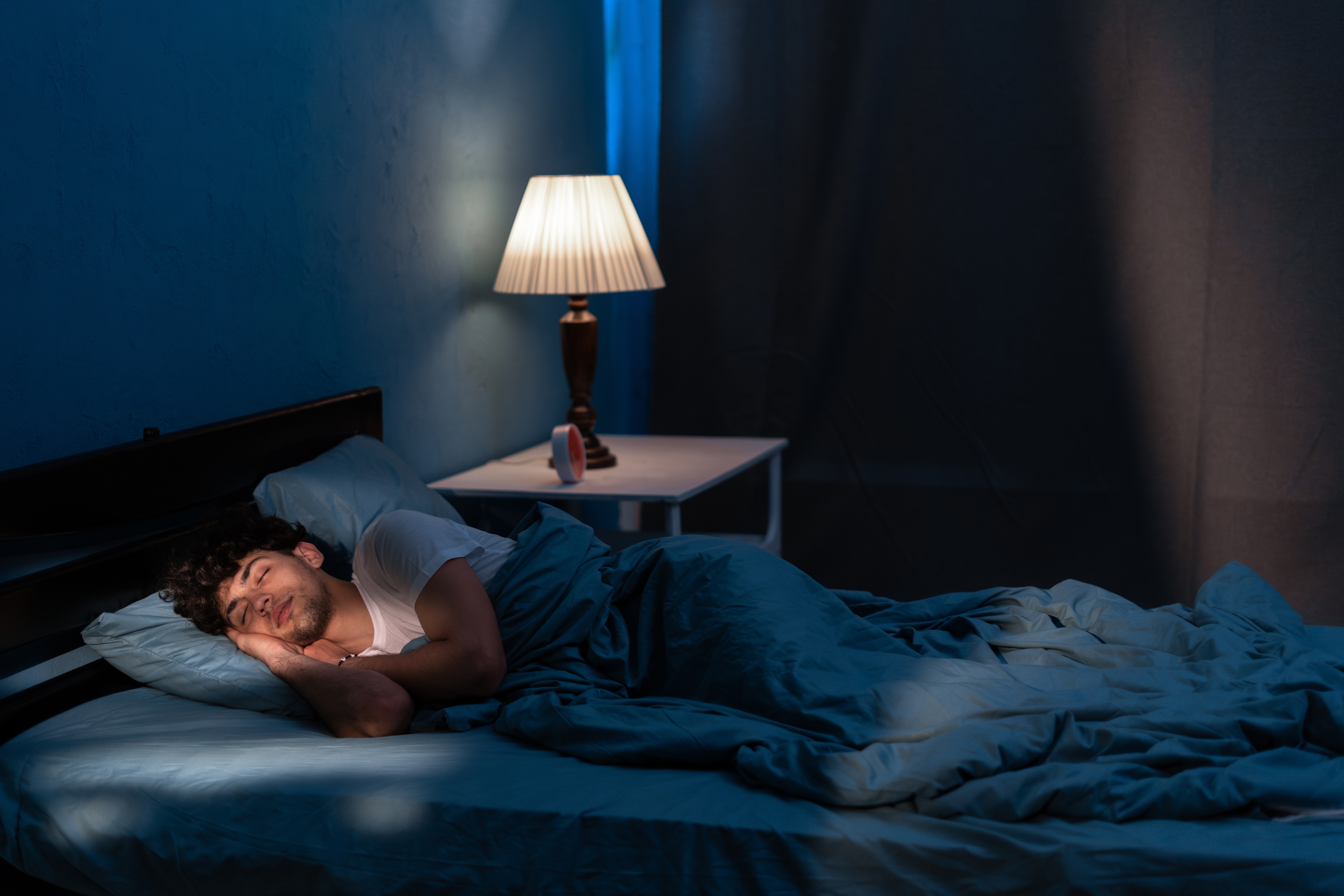 Man sleeping in bed at home at night. | Source: Shutterstock