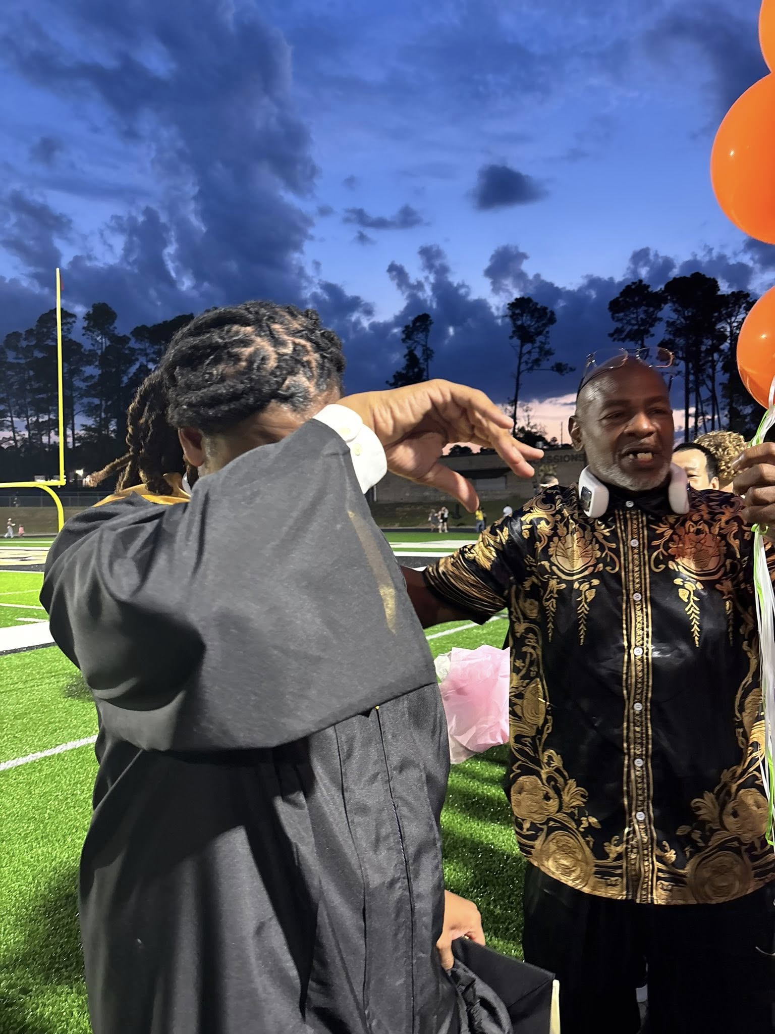 Kencerio Walker and James Walker looking emotional during his graduation on May 22, 2026 | Source: Facebook/Lisa Kennedy