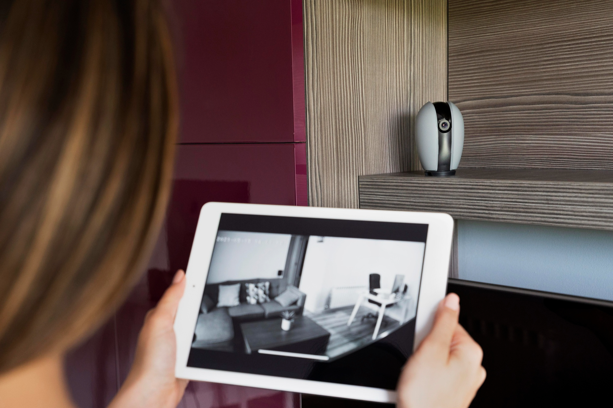 A woman checking her home camera system | Source: Freepik