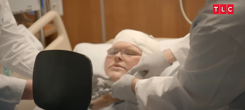 Tammy holds a mirror as the doctor lifts the bandages from her face, from a video posted on June 11, 2025 | Source: YouTube/AccessHollywood