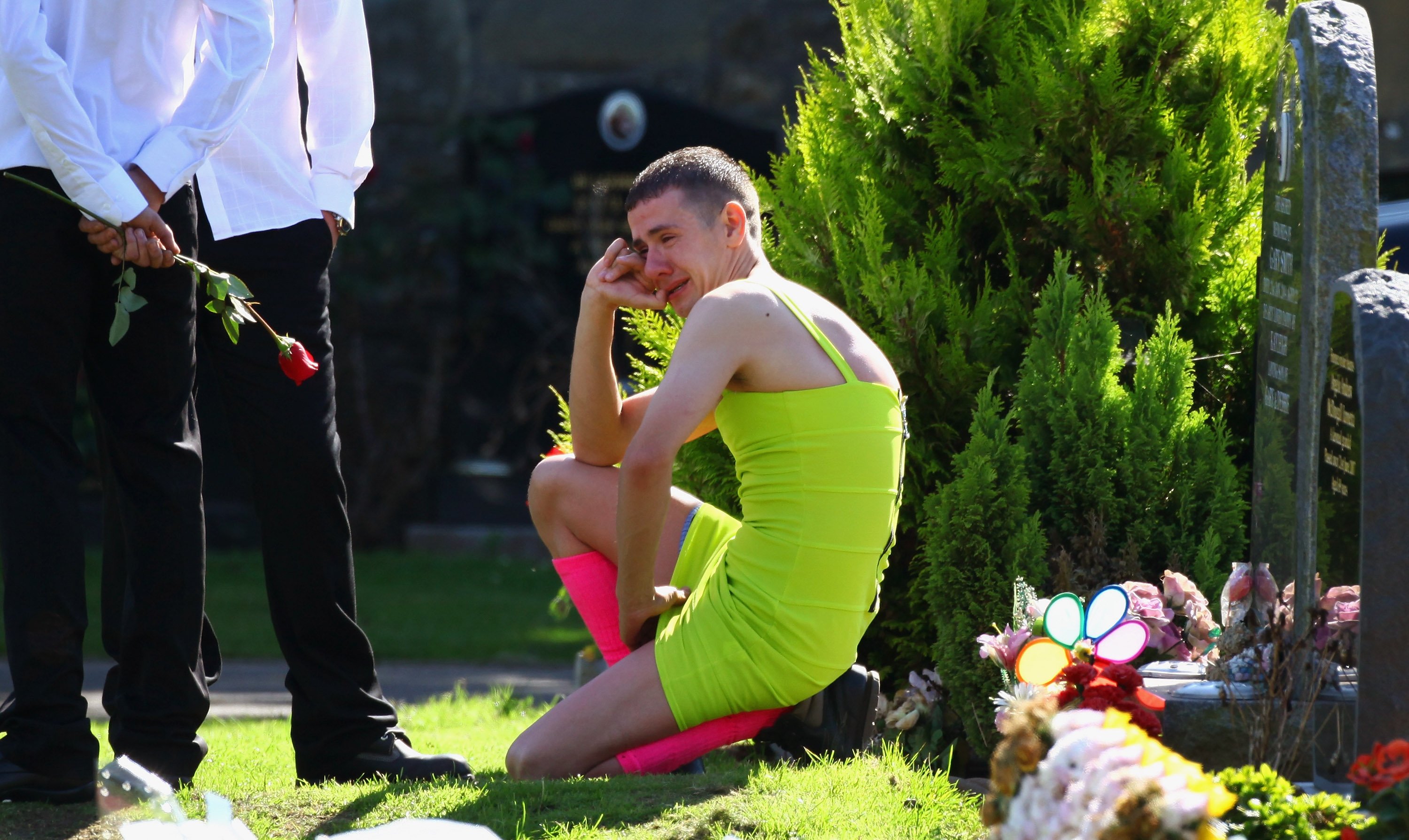 Barry Delaney wearing the lime-green dress, weeping as mourners gather at Barnhill Cemetery for the funeral of  Kevin Elliot in Dundee, Scotland | Photo: Jeff J Mitchell/Getty Images