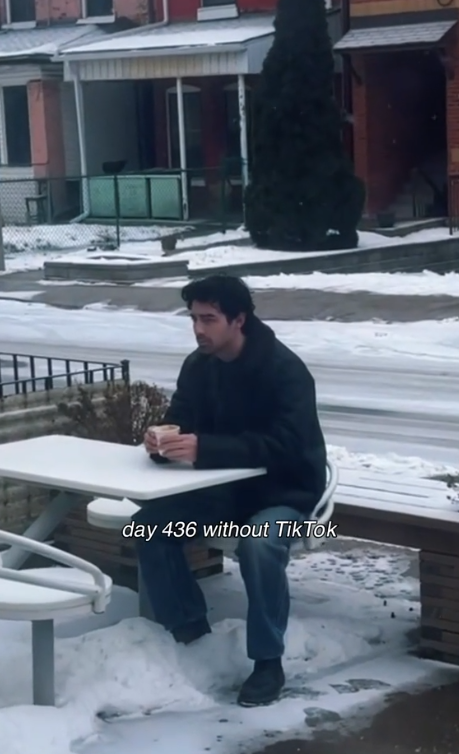 Joe Jonas looking gloomy while sitting outside on a snowy day | Source: TikTok.com/@joejonas