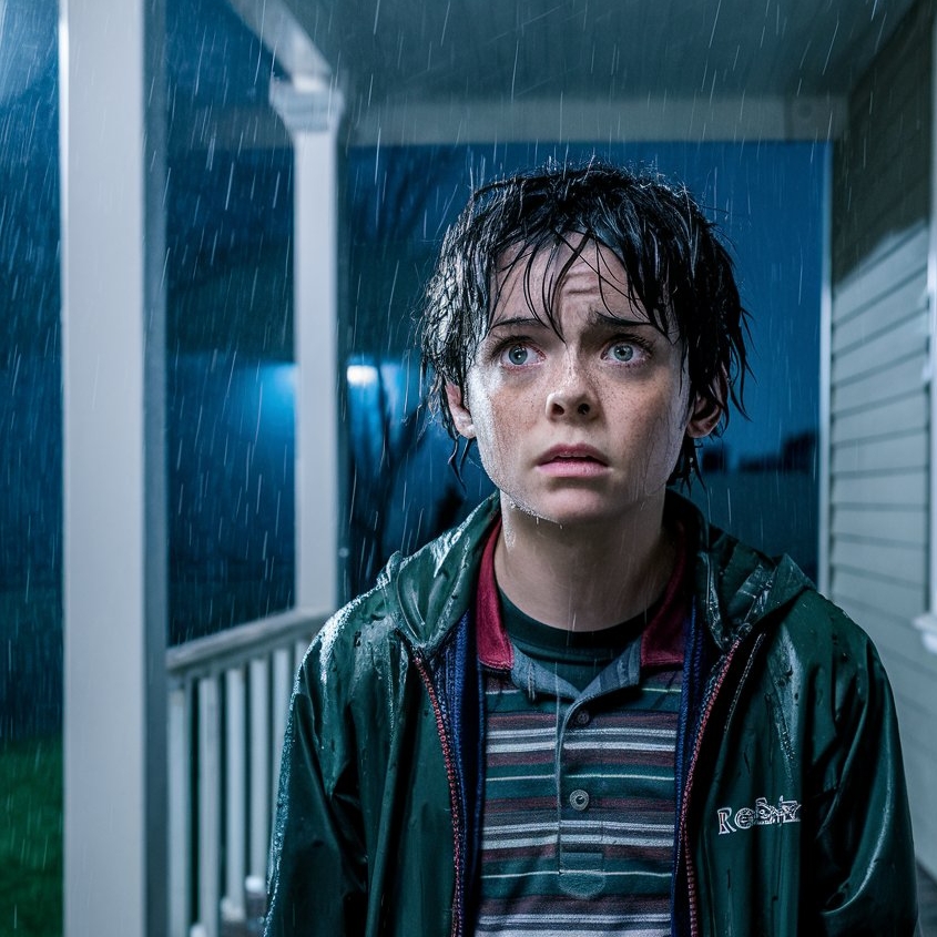 A soaking wet young boy standing on a front porch, looking concerned | Source: Midjourney