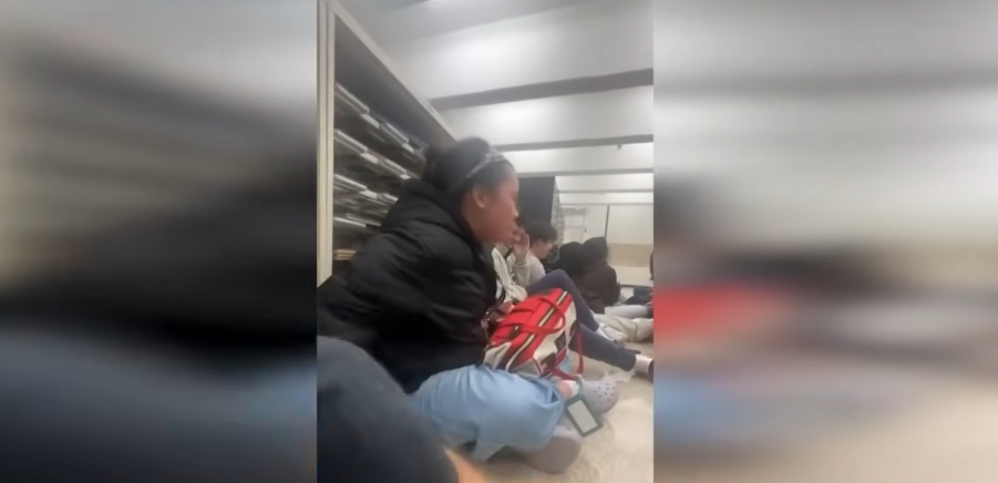 Students hiding next to library file shelves while authorities bang on the door, dated December 14, 2025 | Source: YouTube/WCVB Channel 5 Boston