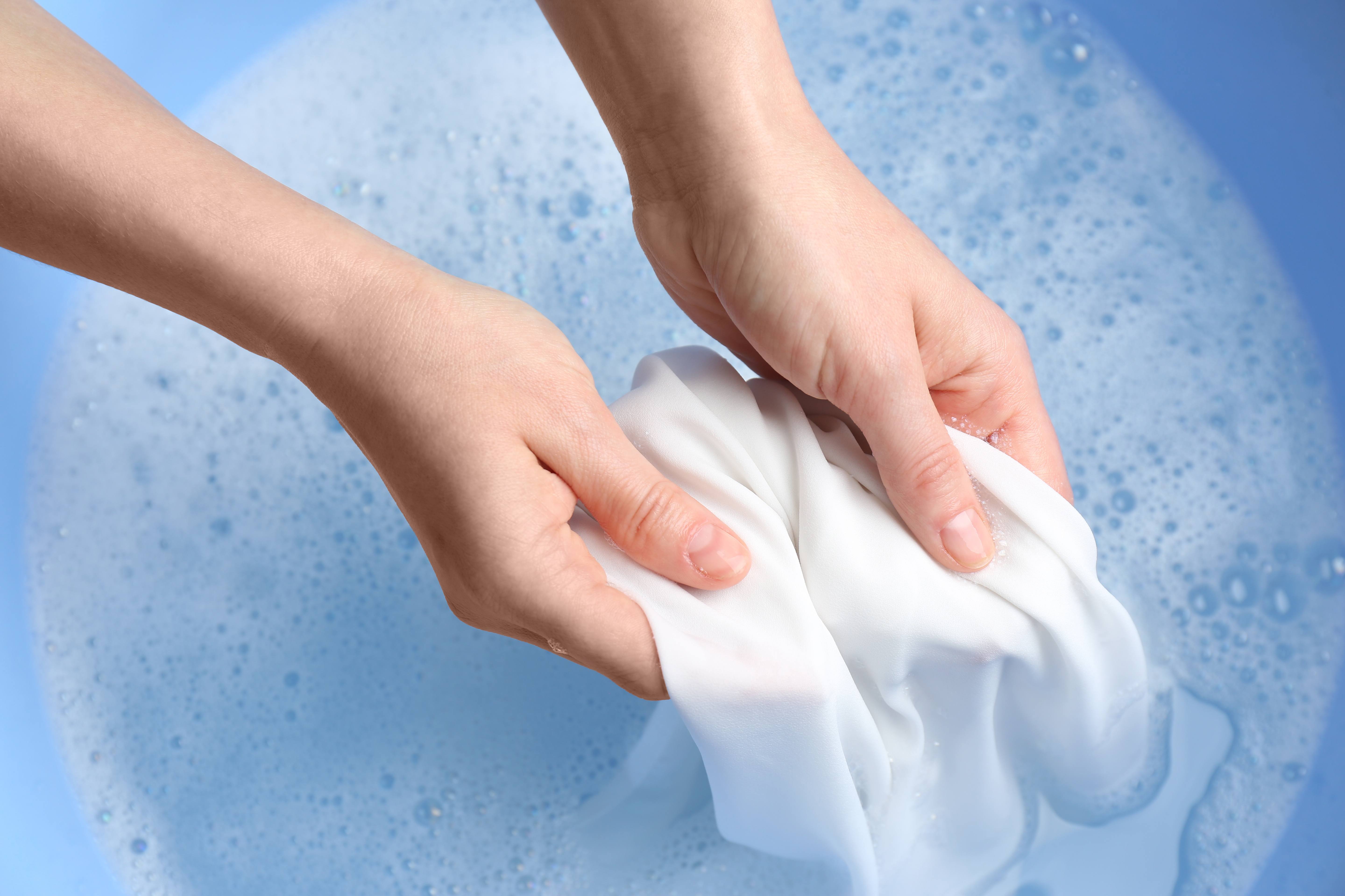 Woman handwashing a garment. | Source: Shutterstock