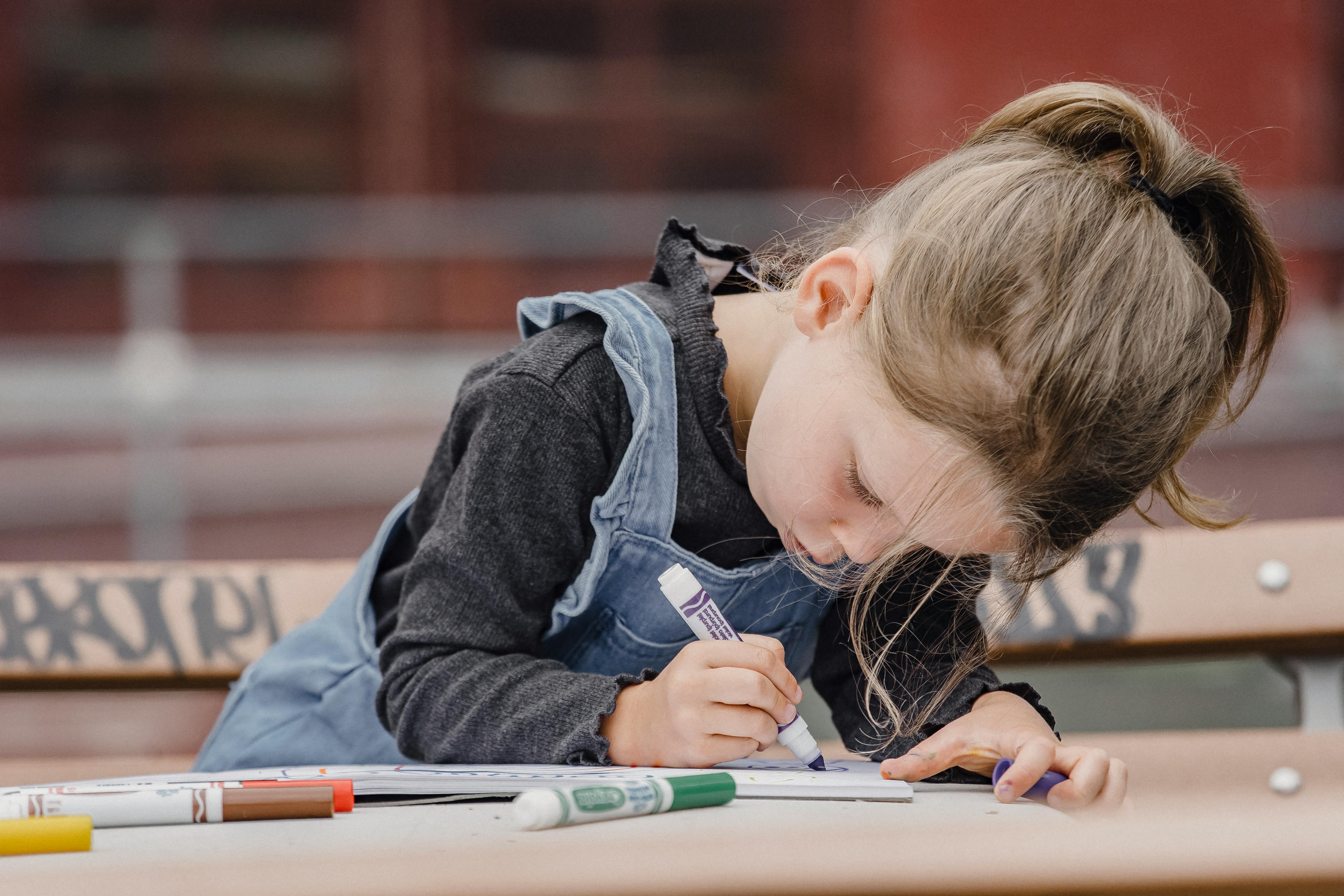 A little girl coloring in her book | Source: Pexels