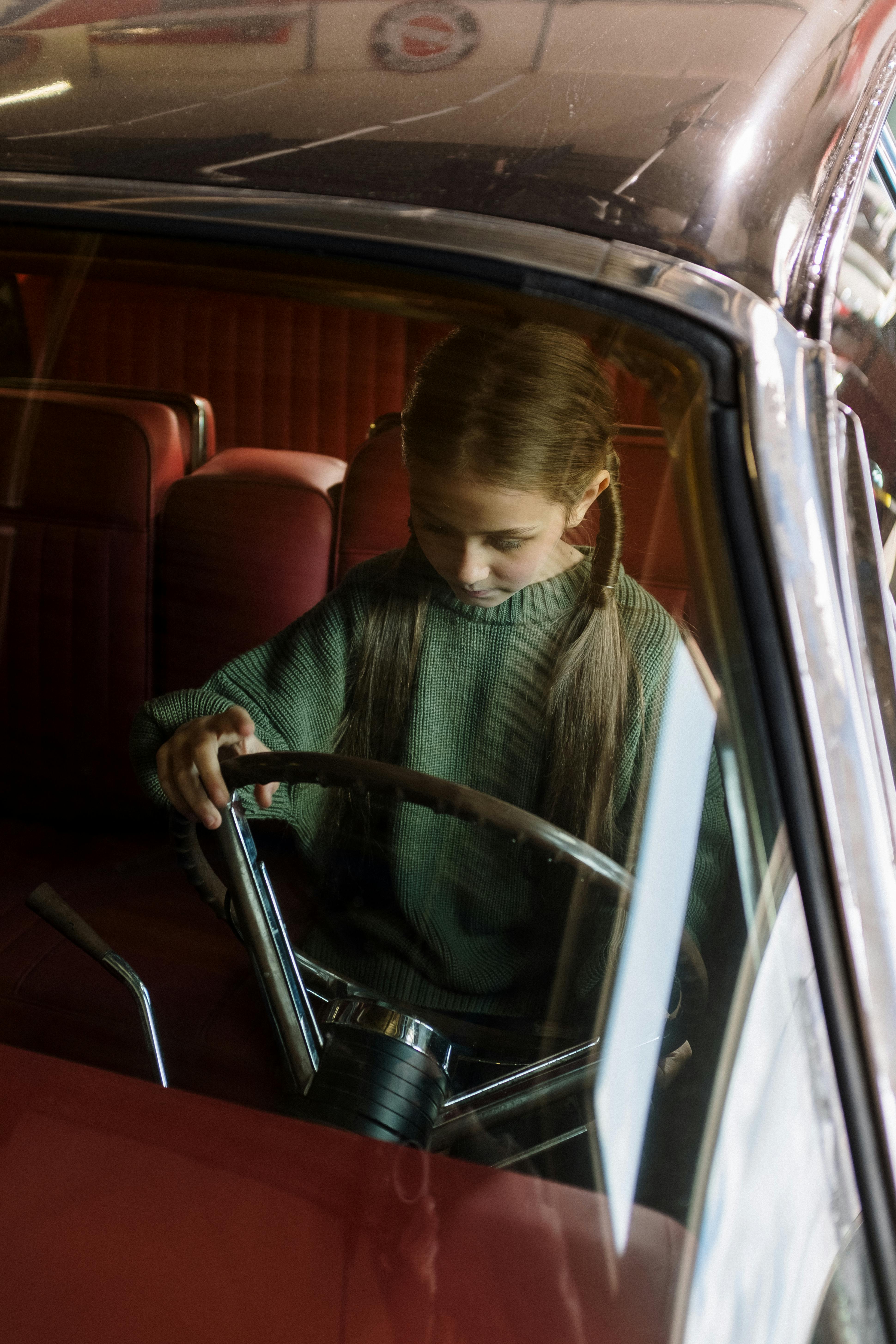 A little girl playing in a parked car | Source: Pexels