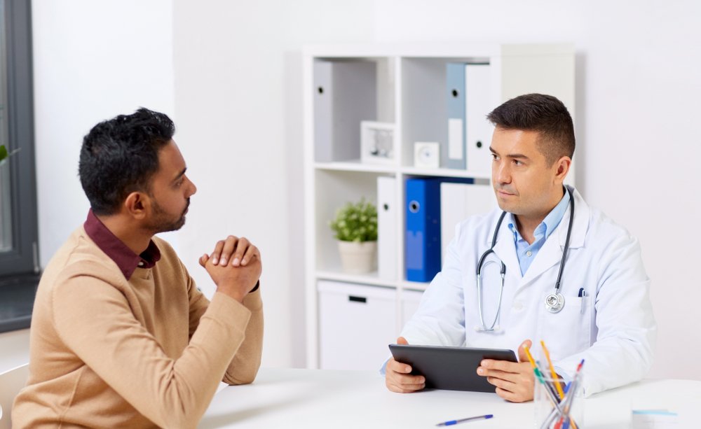 A photo of a doctor talking to a male patient. | Photo: Shutterstock