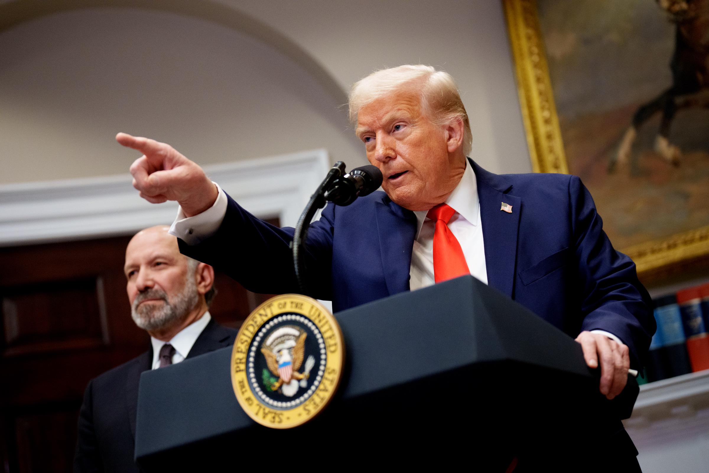 U.S. President Donald Trump, accompanied by Commerce Secretary Howard Lutnick (L) takes a question from a reporter in the Roosevelt Room of the White House on March 3, 2025, in Washington, D.C. | Source: Getty Images