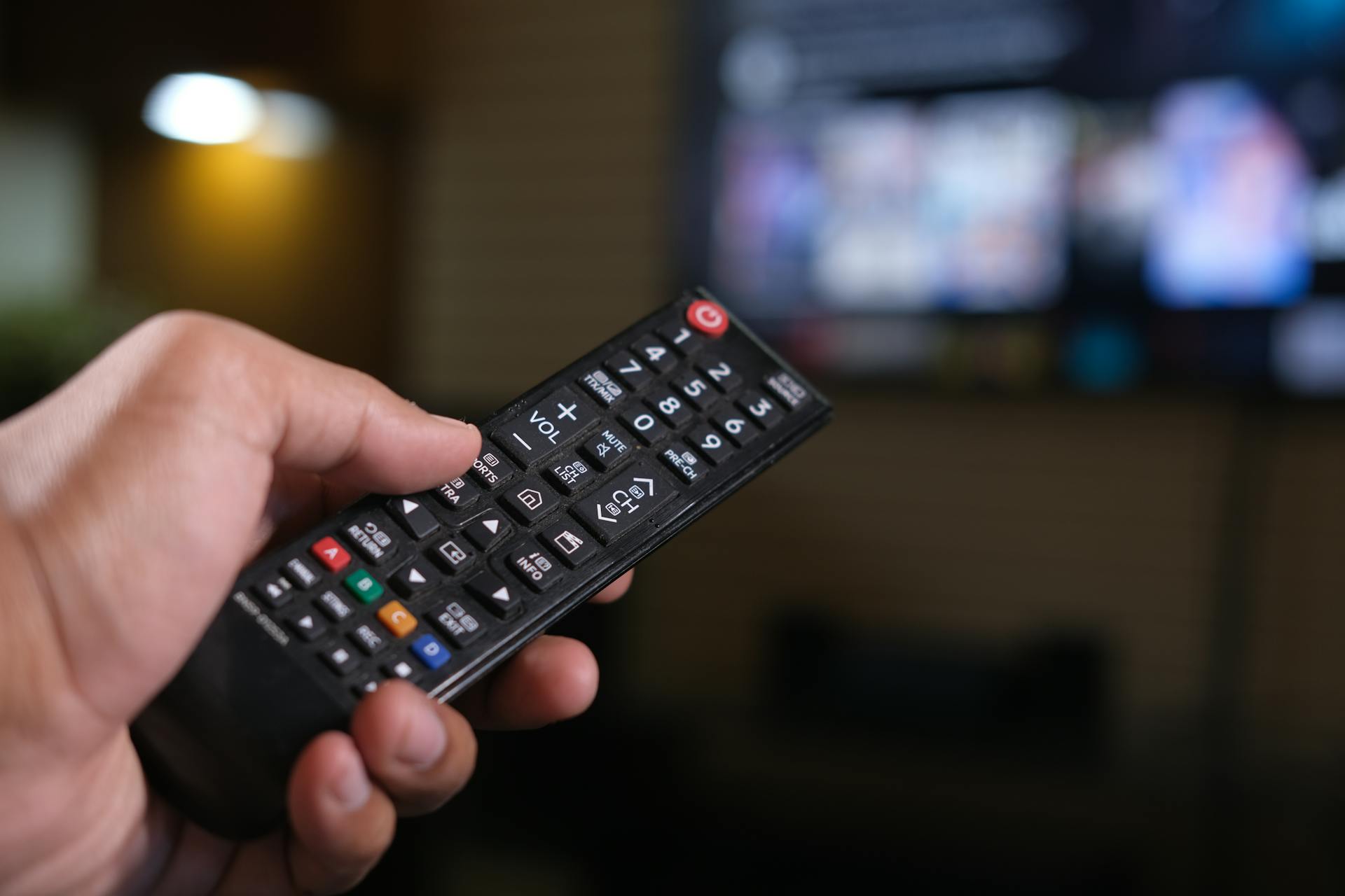 Man holding a TV remote | Source: Pexels