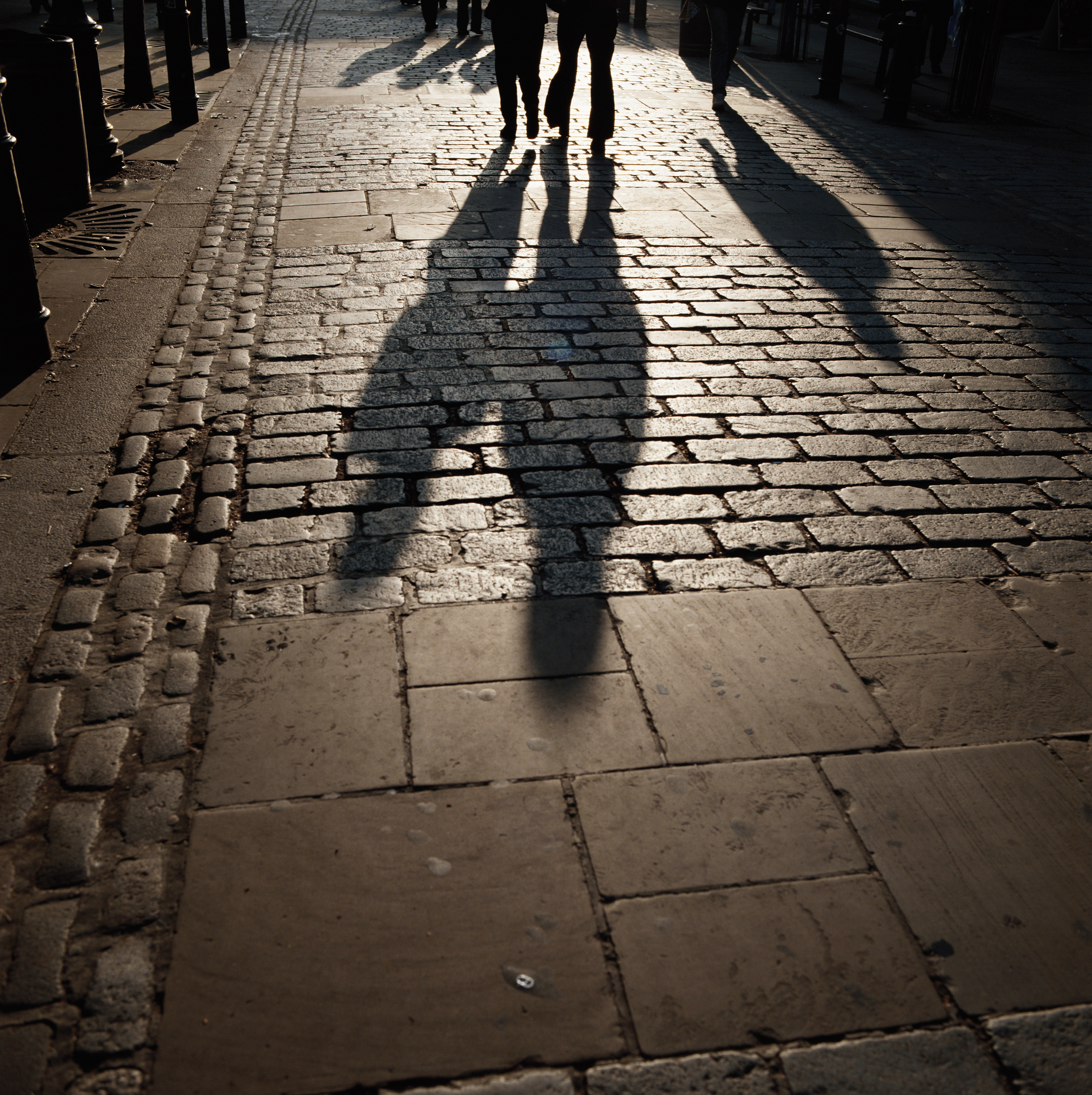 Shadow of people walking on footpath | Source: Getty Images