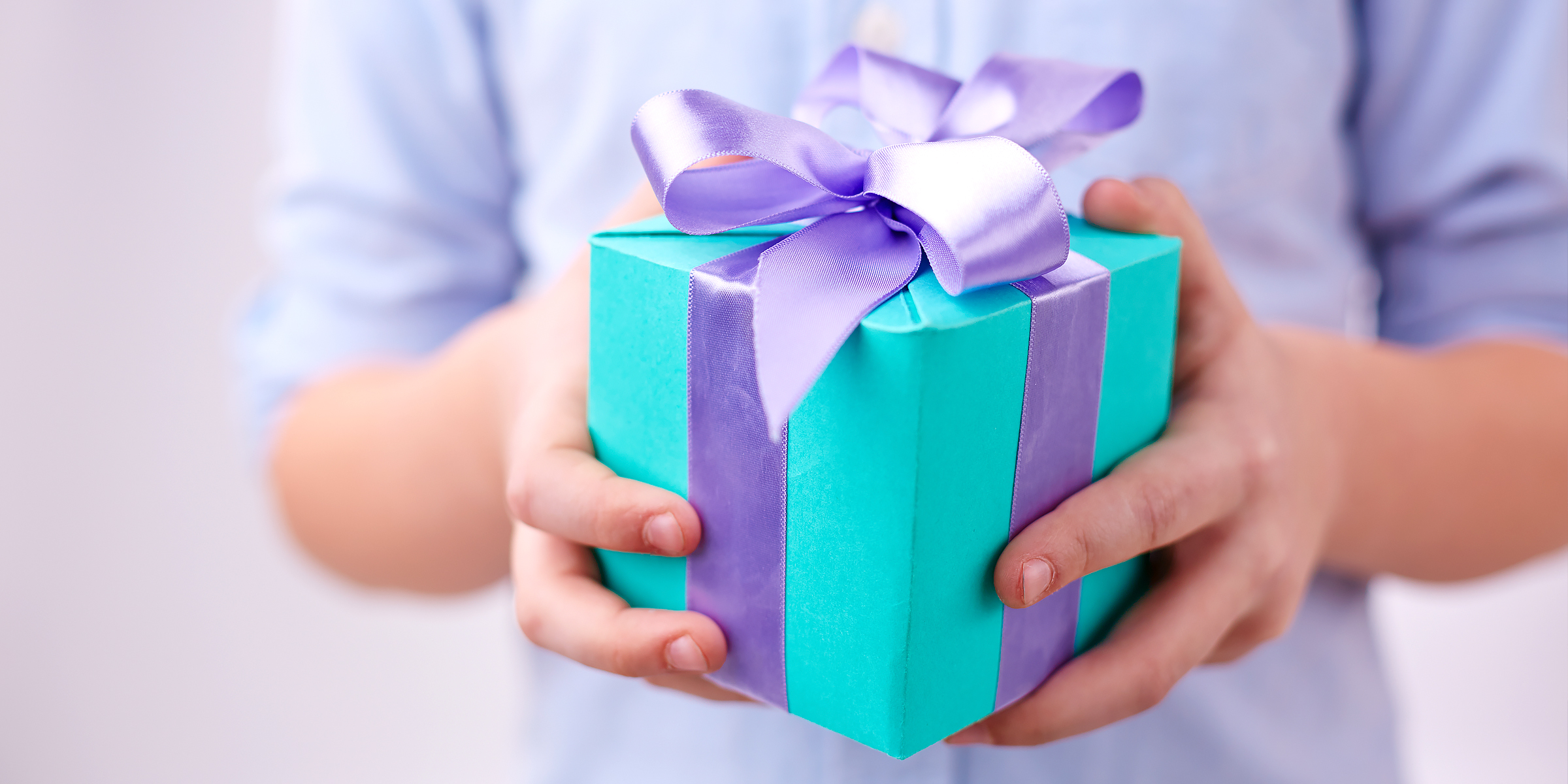 Boy holding present box | Source: Shutterstock