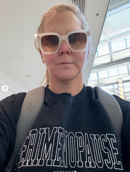 Amy Schumer snapped a no-makeup selfie while wearing oversized white sunglasses and a sweatshirt that boldly read "PERIMENOPAUSE." The noticeably slimmer shape of her face and jawline reflected the results of her body transformation. Shared on January 5, 2026, the image concluded a striking carousel. | Source: Instagram/amyschumer
