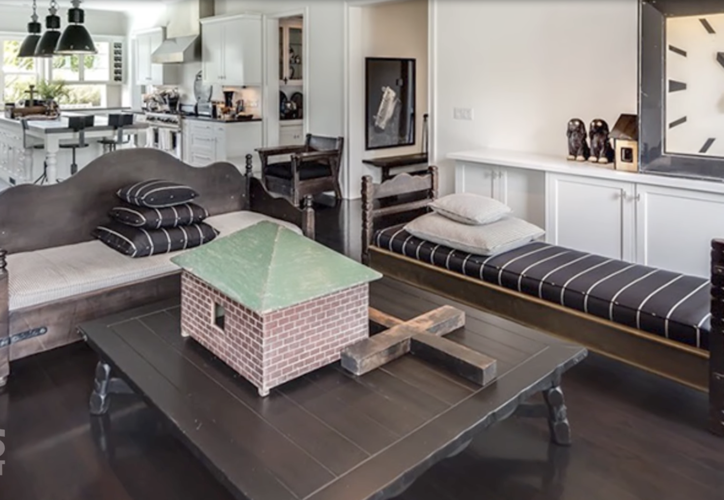 Living space with antique benches, striped cushions, and a miniature brick house centerpiece inside Diane Keaton’s Sullivan Canyon home, dated February 3, 2022 | Source: YouTube/@FamousEntertainment500k