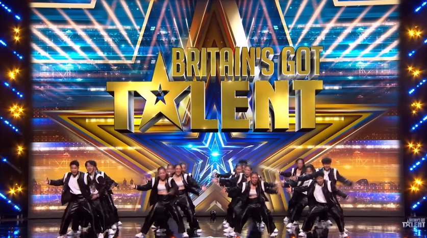Dance troupe World Wings deliver a high-energy group routine on the "Britain's Got Talent" stage, set against the show's iconic gold star backdrop. | Source: YouTube/Britain's Got Talent