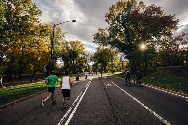 Des hommes qui courent dans un parc | Photo : Unsplash.