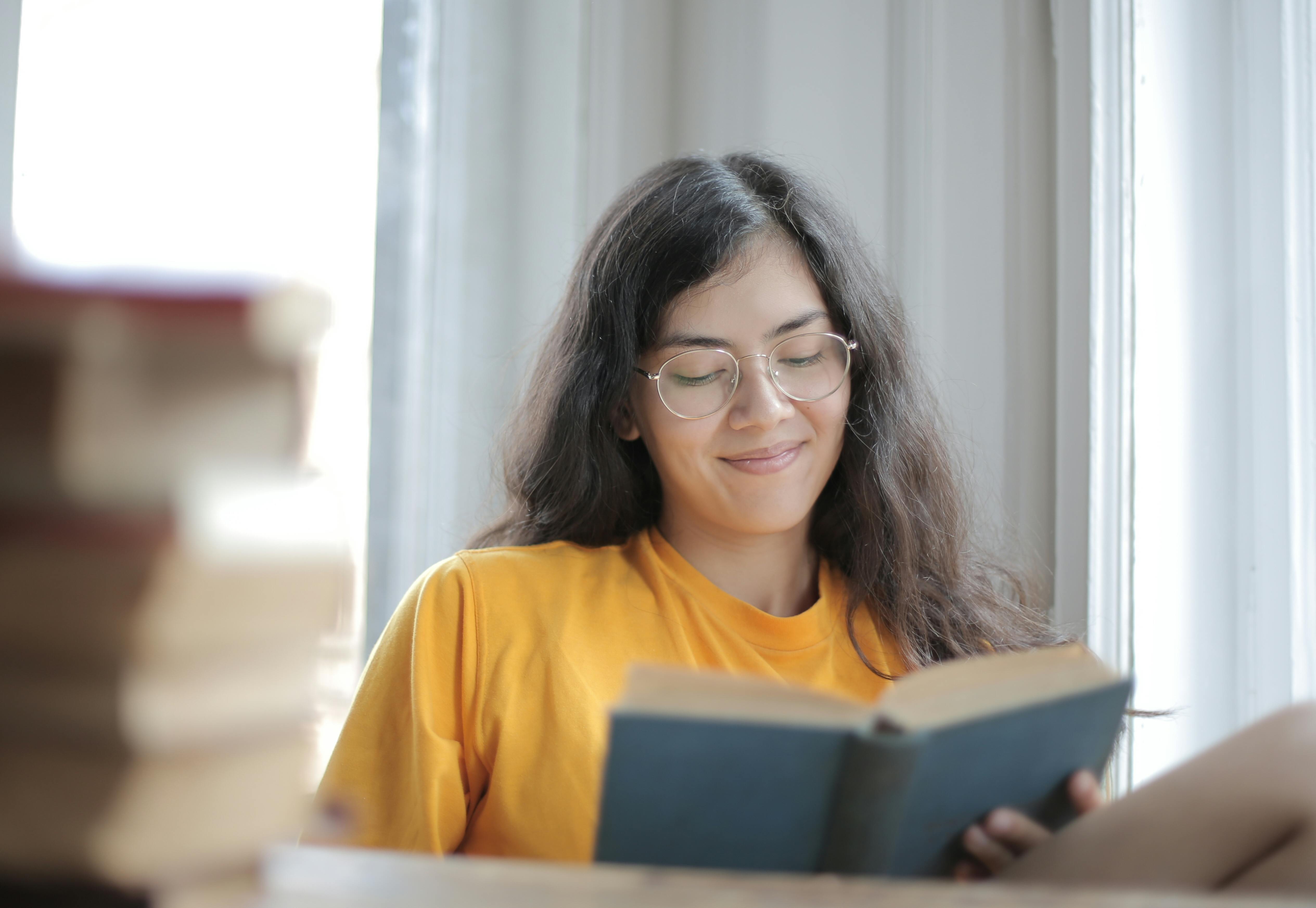 A woman reading a book at home | Source: Pexels