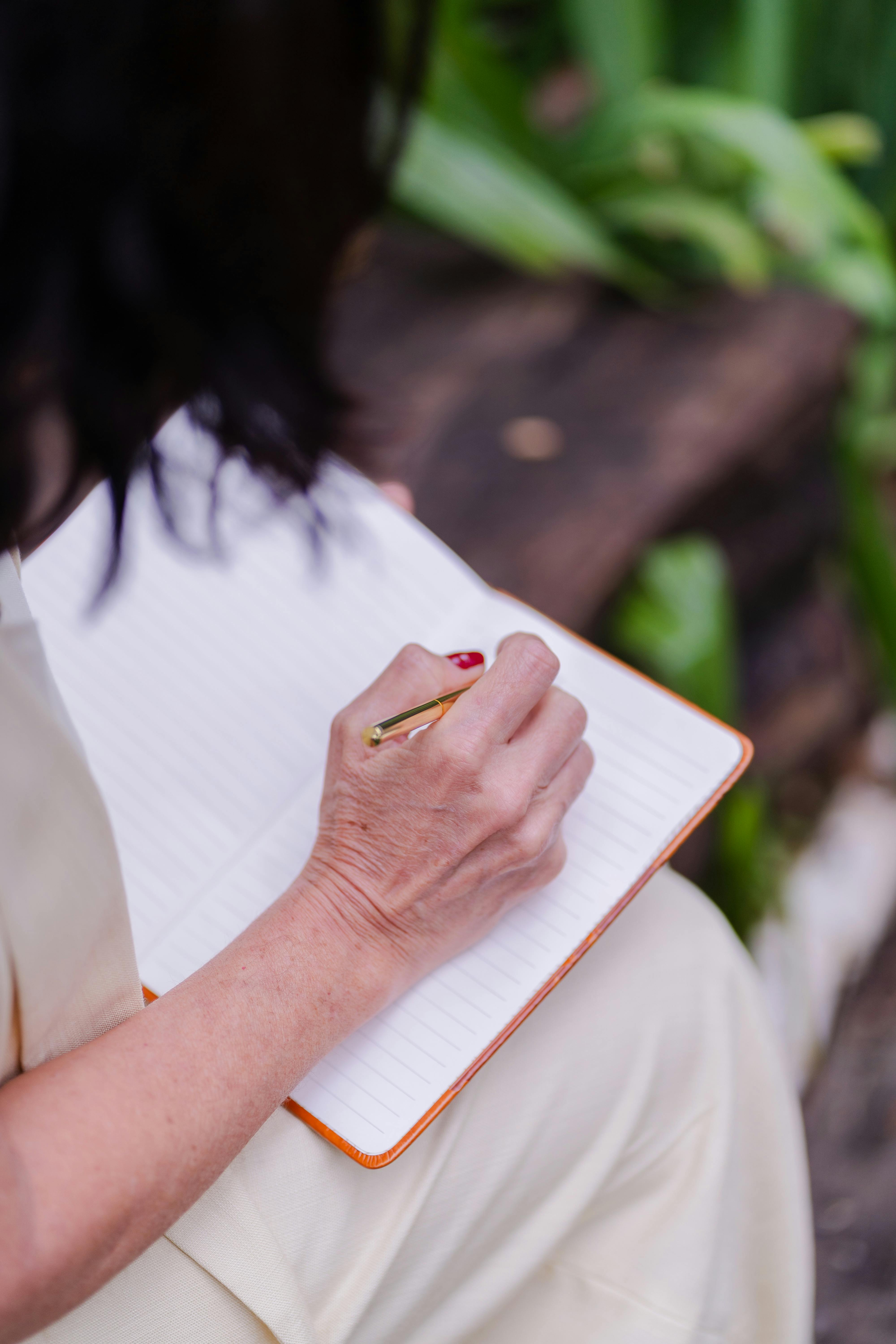 A woman journaling outdoors | Source: Pexels