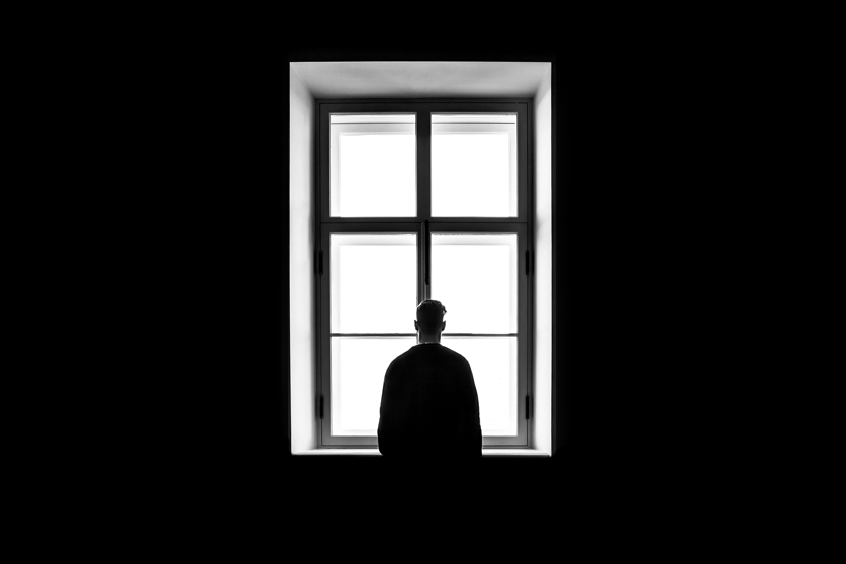 A man staring out the window while deep in thought | Source: Shutterstock