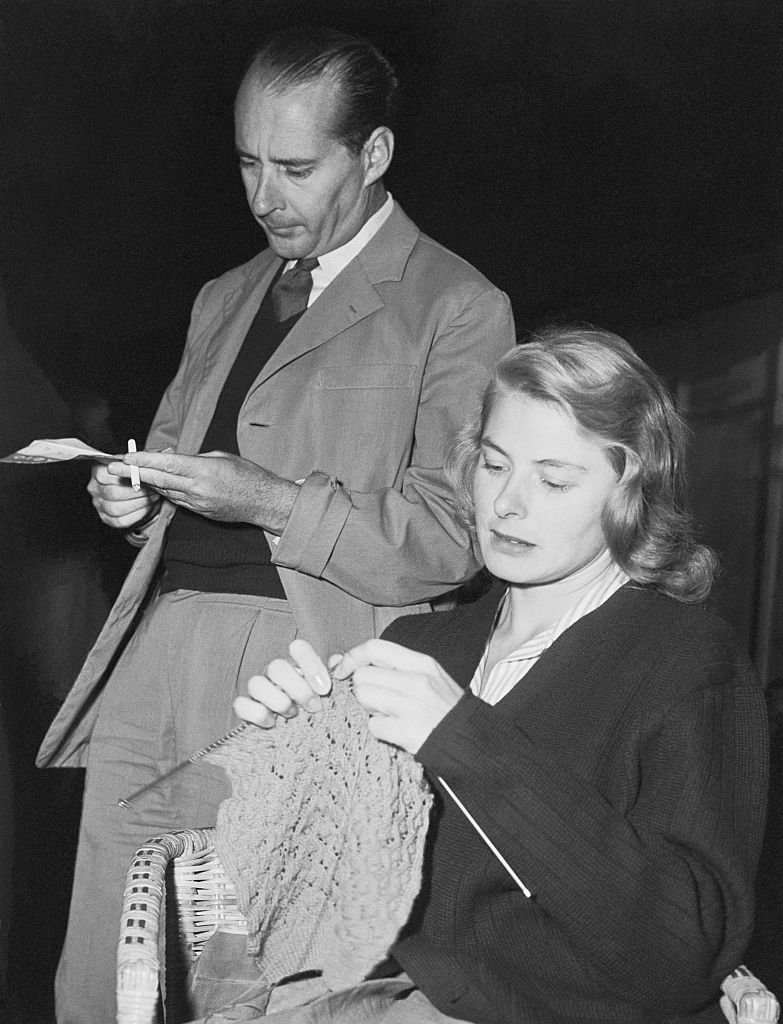 Ingrid Bergman knitting with her second husband Italian Director Roberto Rossellini beside her | Source: Getty Images