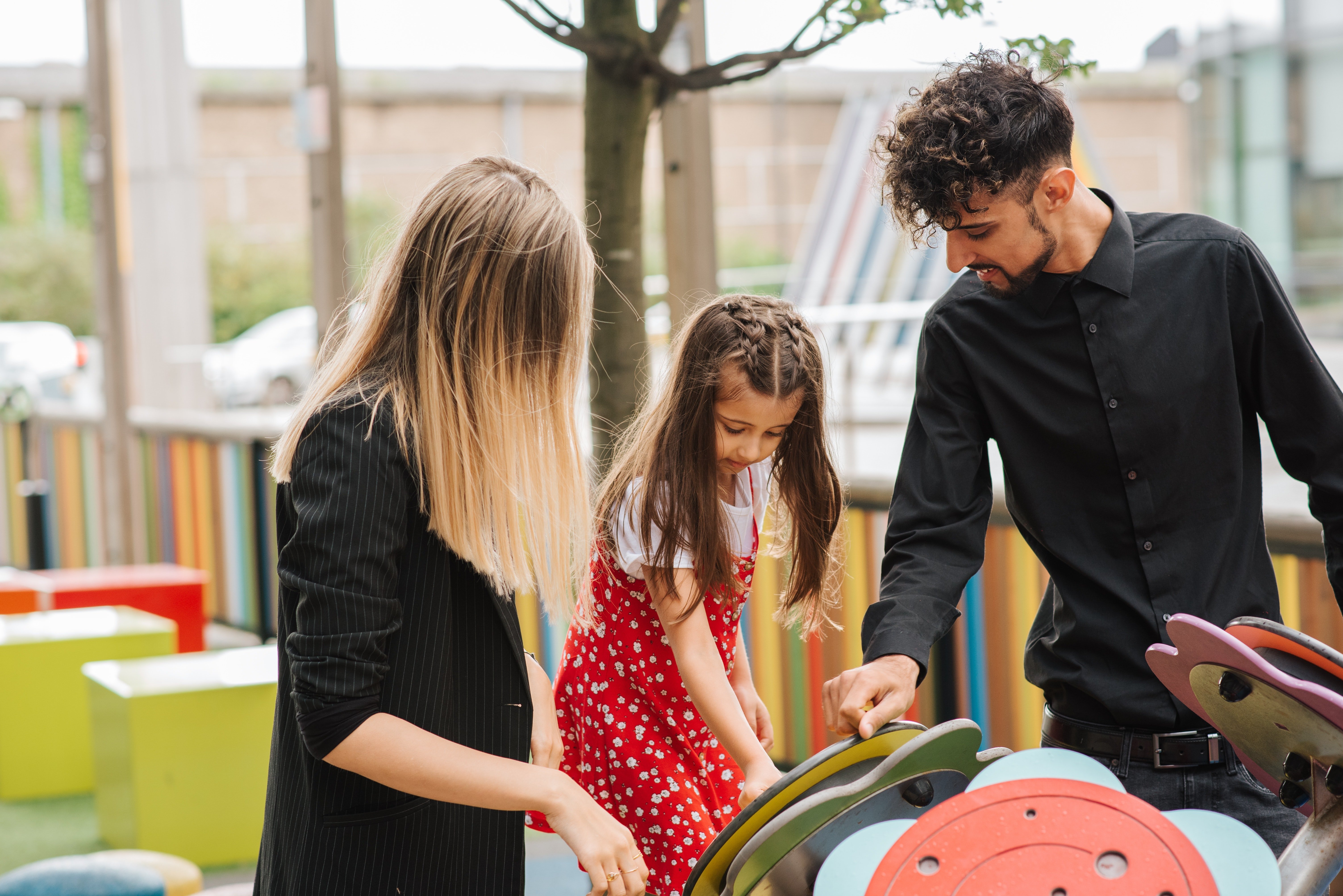Jóvenes con una niña en un parque. | Foto: Pexels