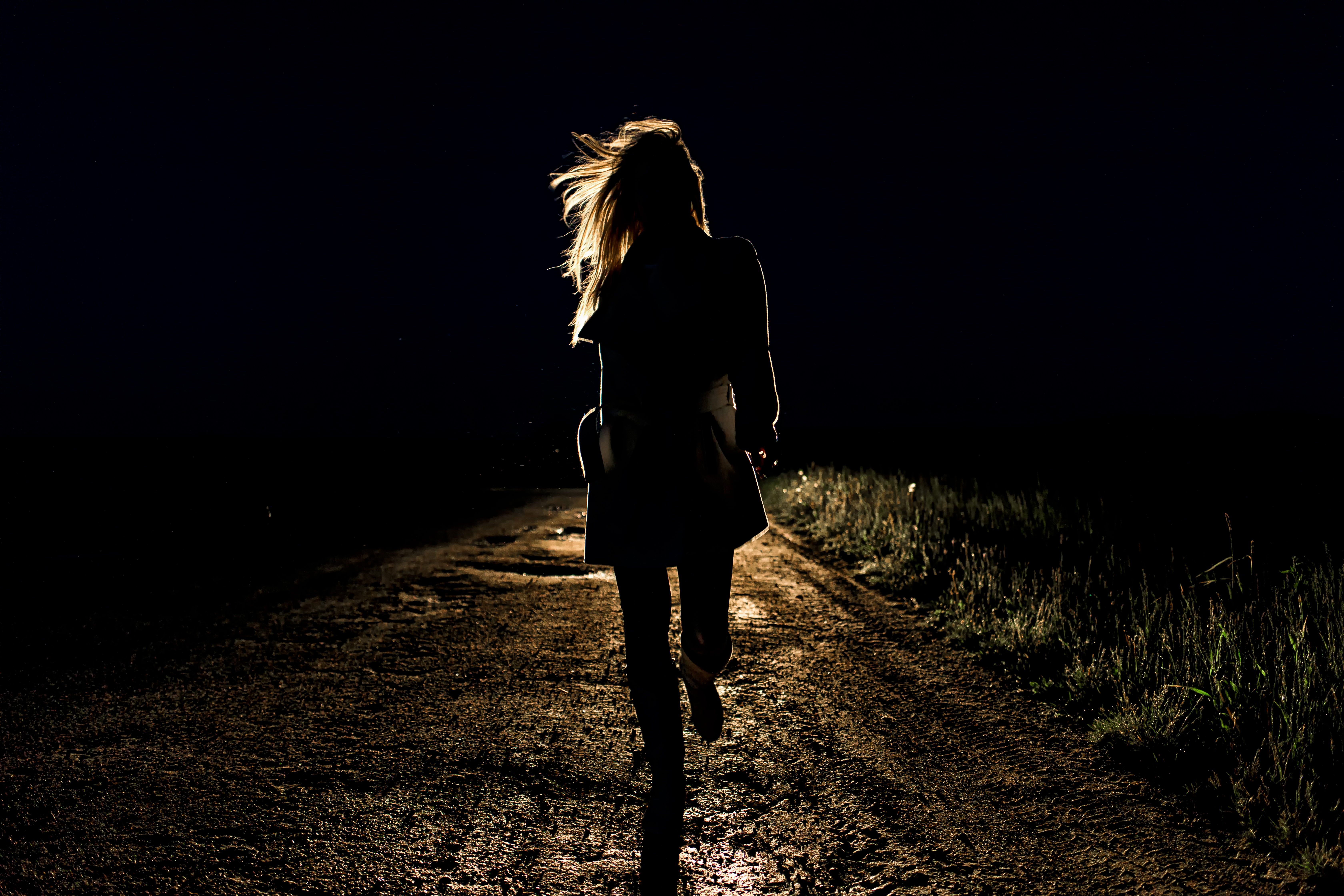 Lonely woman running away from car at night | Source: Shutterstock.com