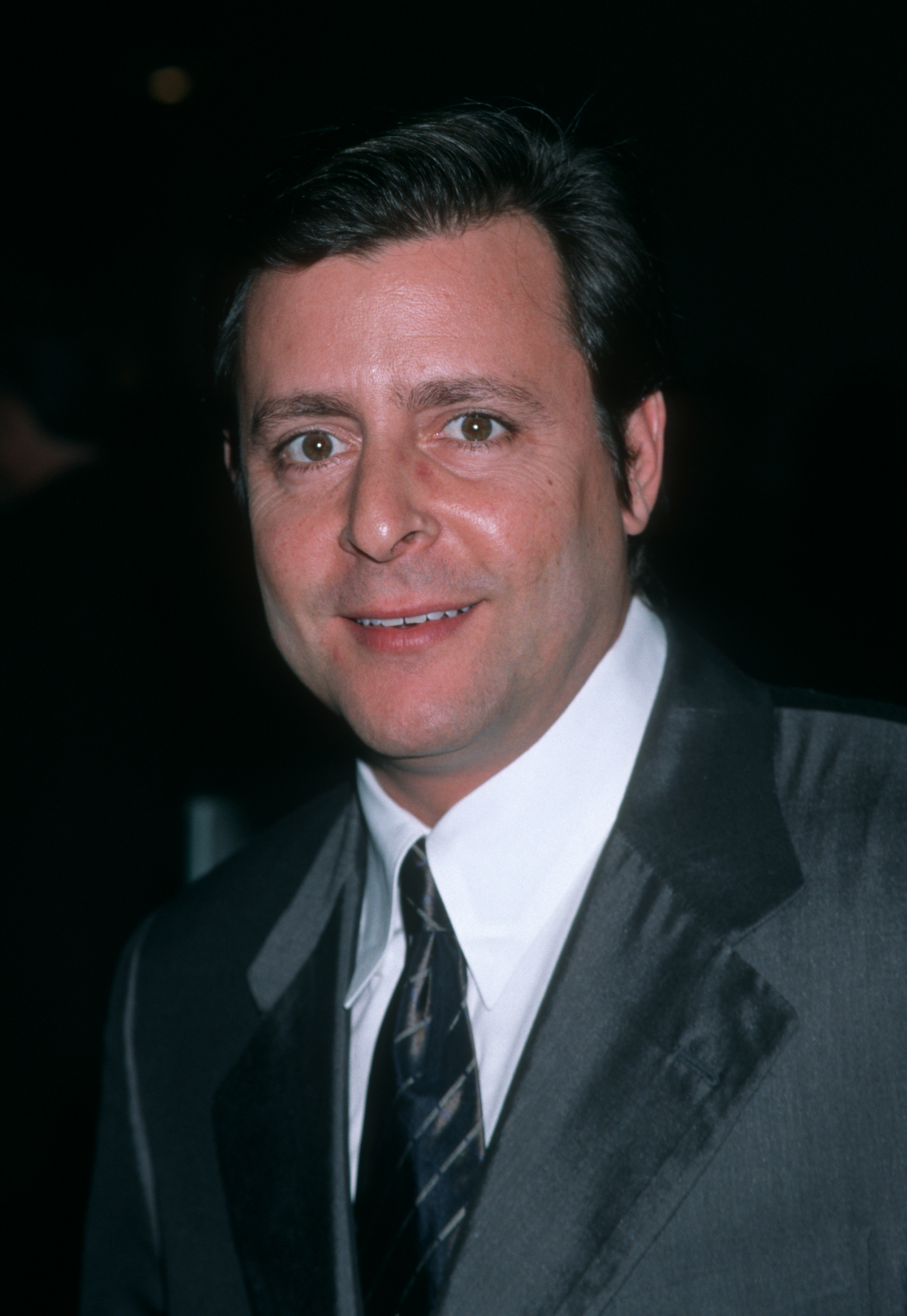 Dressed in a sleek dark suit and crisp white shirt, the performer offered a warm smile while attending the Skirball Cultural Center Awards at the Shrine Auditorium. | Source: Getty Images
