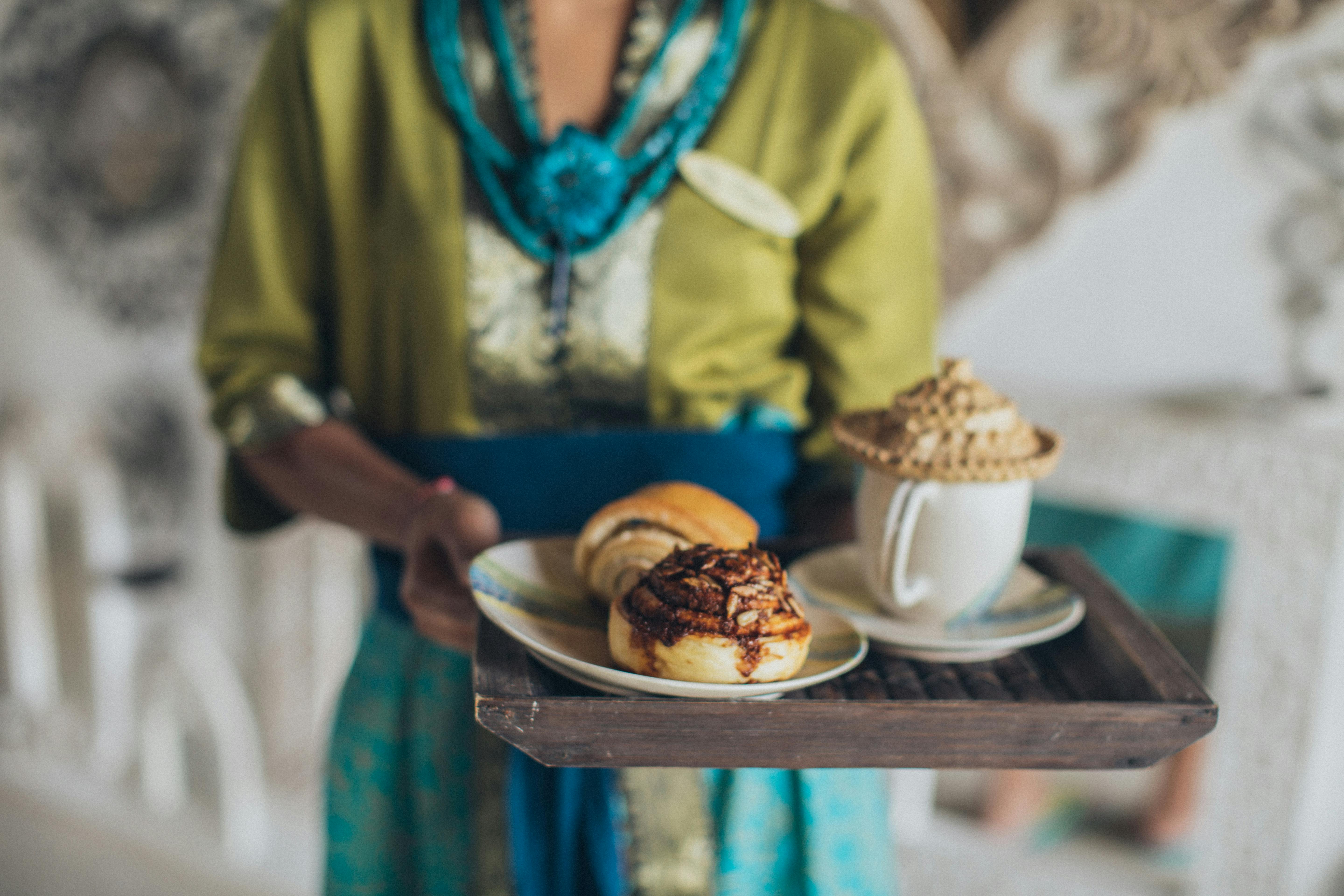 A woman holding some baked goods on a tray | Source: Pexels