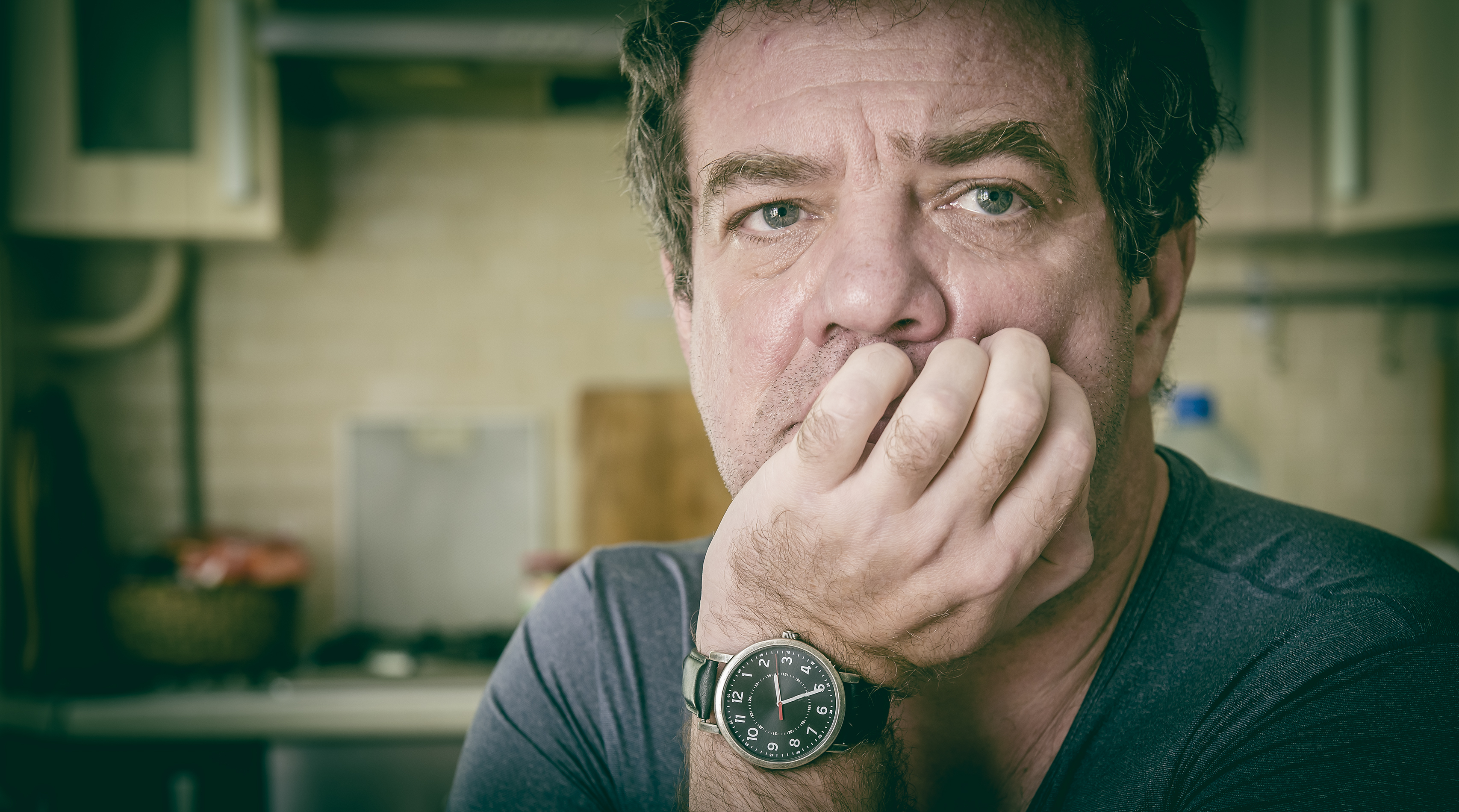 A man sitting with his face resting on his palm | Source: Shutterstock