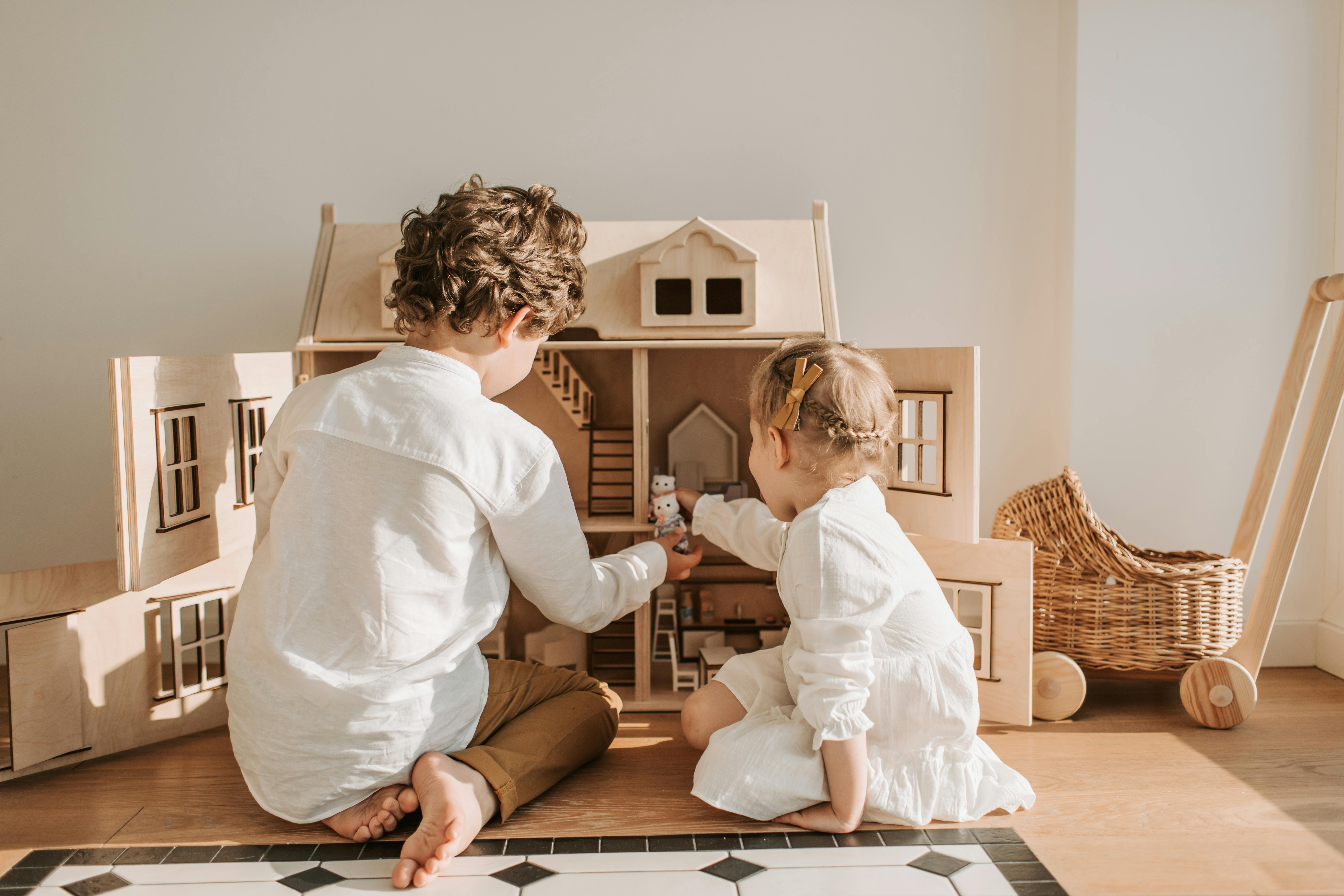 Two kids playing with a doll house | Source: Pexels