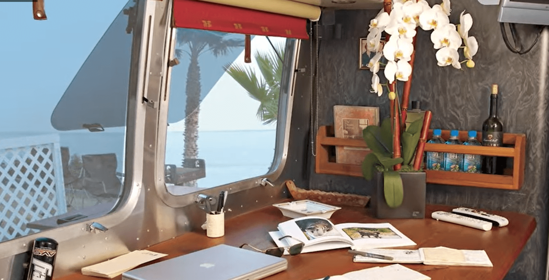 A desk and windows inside an Airstream trailer | Source: YouTube/Famous Entertainment