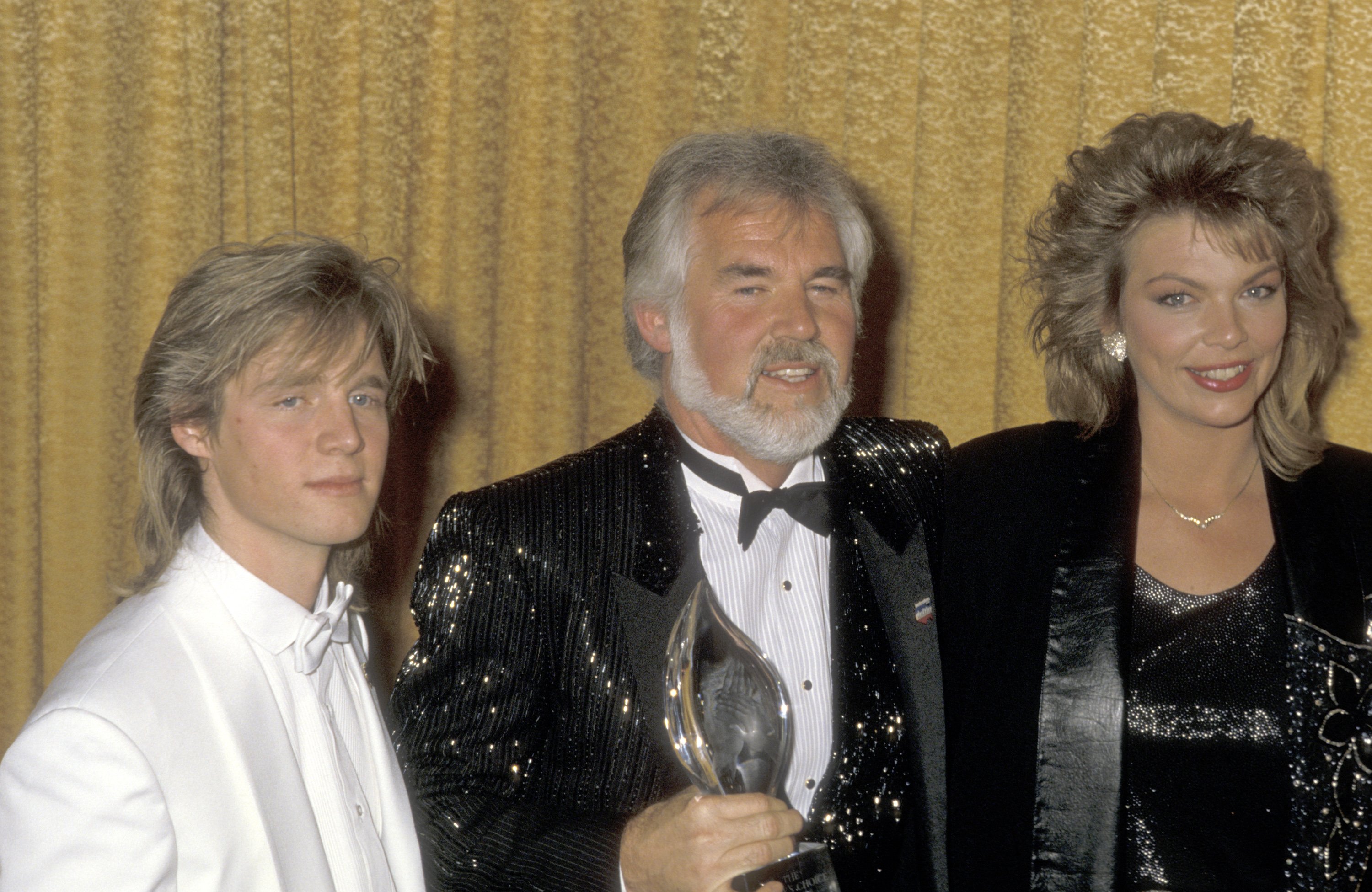 Kenny Rogers is pictured with his children, Kenny Rogers Jr. and Carole Rogers, at the 12th Annual People's Choice Awards on March 11, 1986 at the Santa Monica Civic Auditorium in Santa Monica, California |  Source: Getty Images