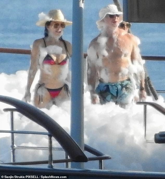 The bride wore an ombre black and red string bikini and the groom wore blue and black swimming trunks