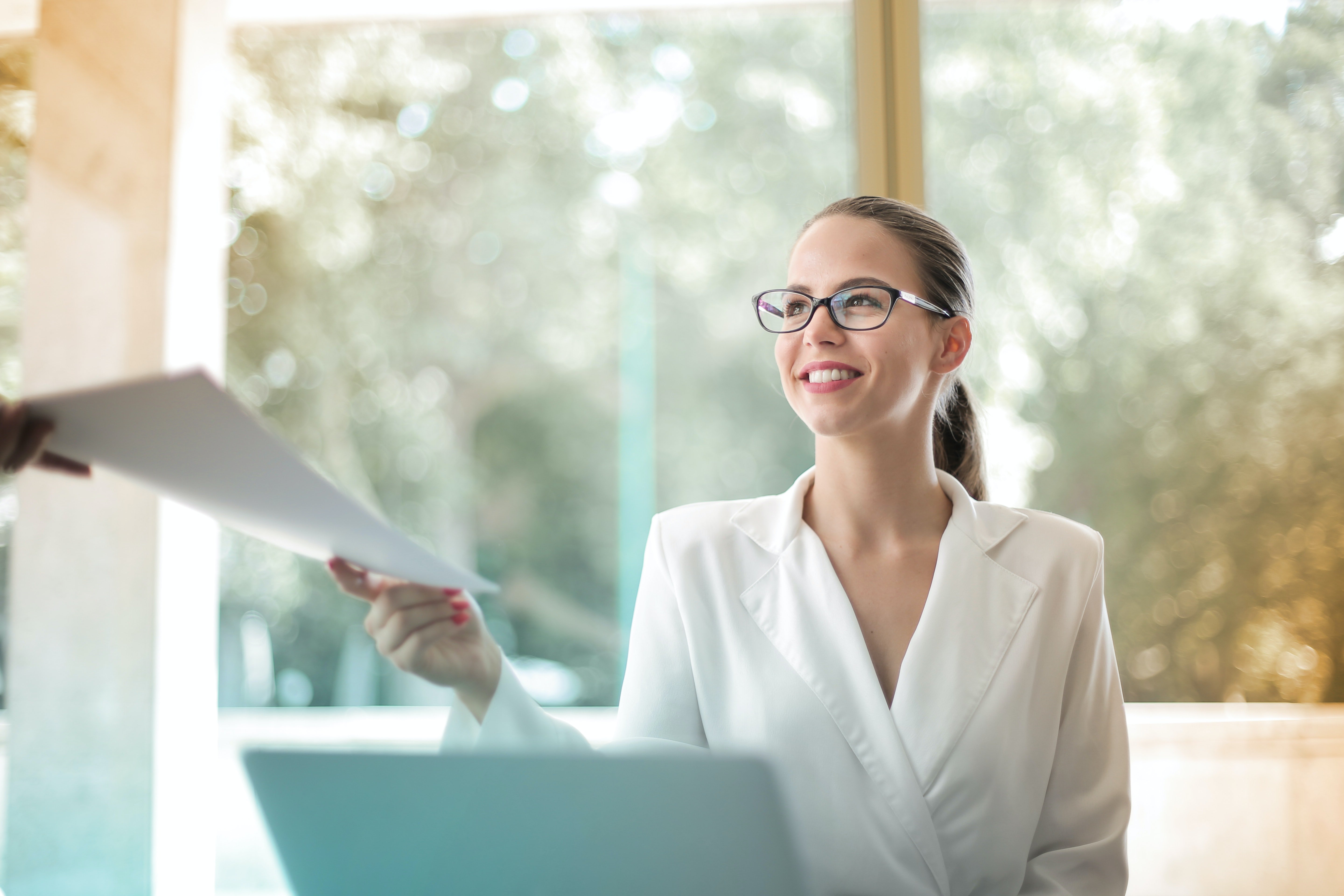 A woman handing over paerwork. | Source: Pexels/ Andrea Piacquadio