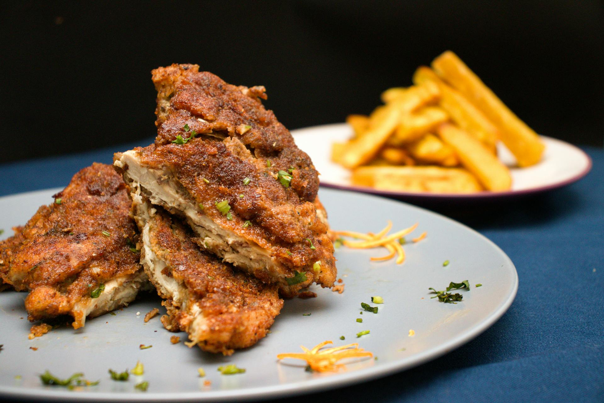 Two plates of deep fried meat and French fries | Source: Pexels