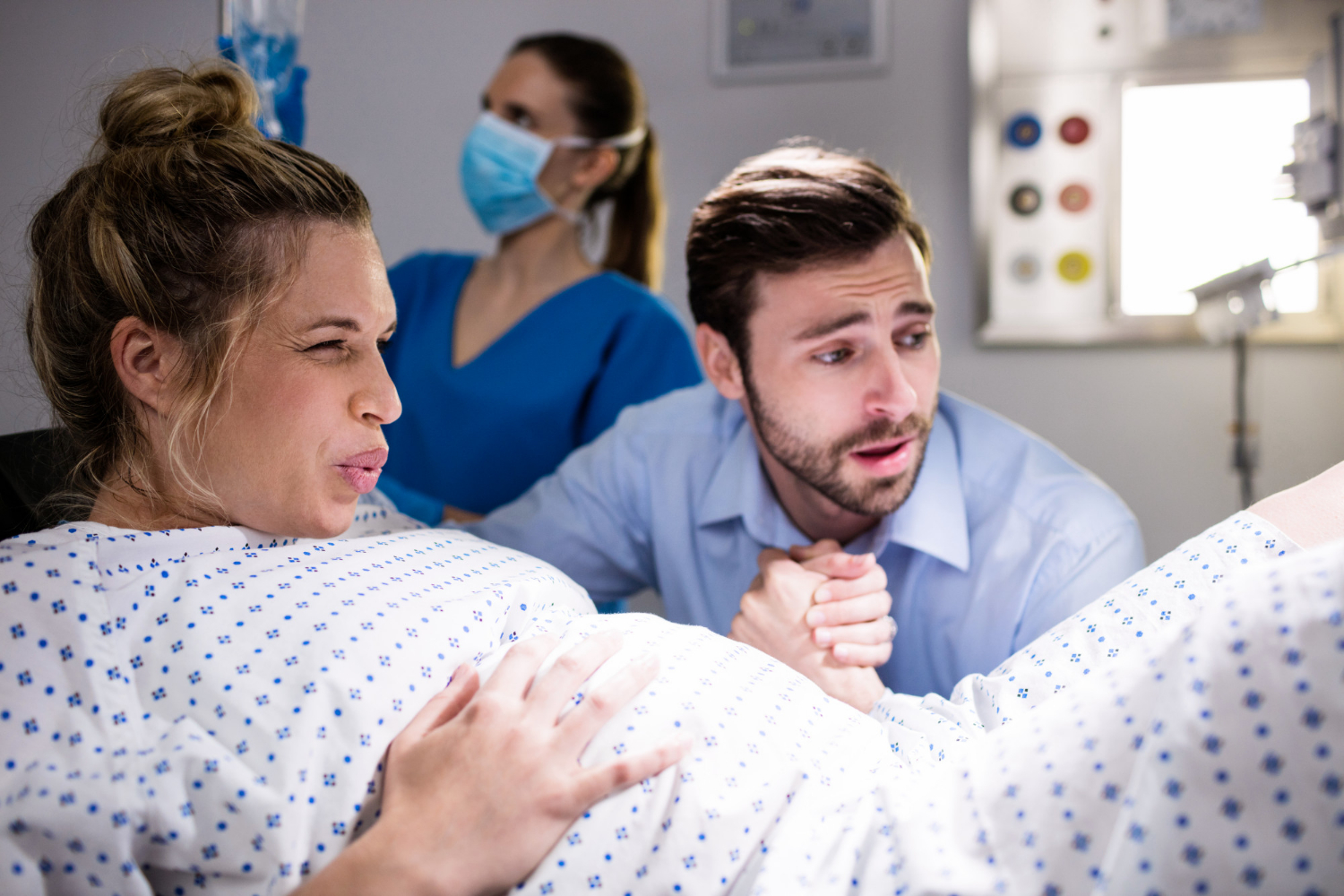 A pregnant woman in labor holding her partner's hand | Source: Freepik